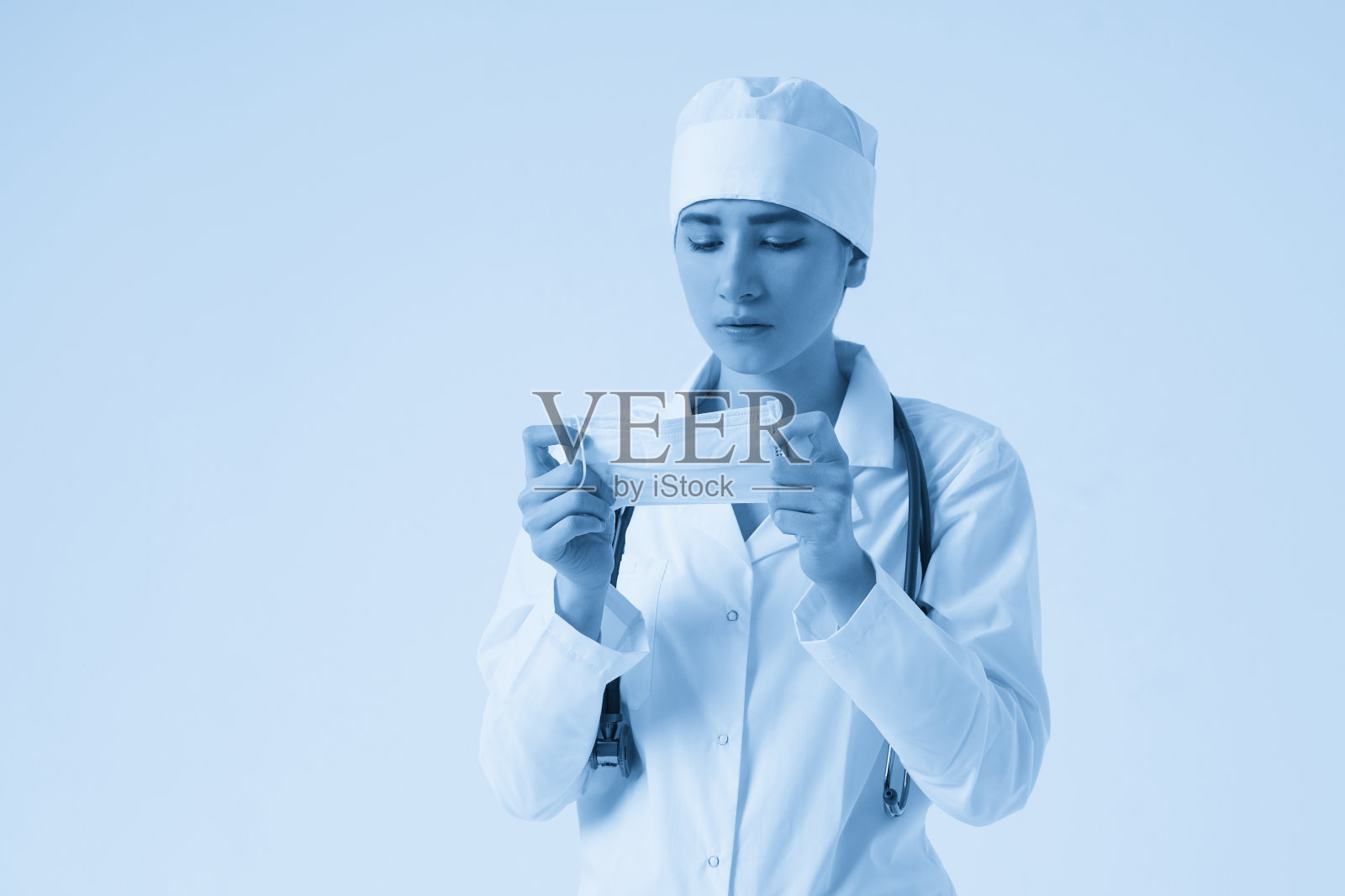 年轻女医生戴医用防护口罩的肖像，白色背景，复制空间照片摄影图片