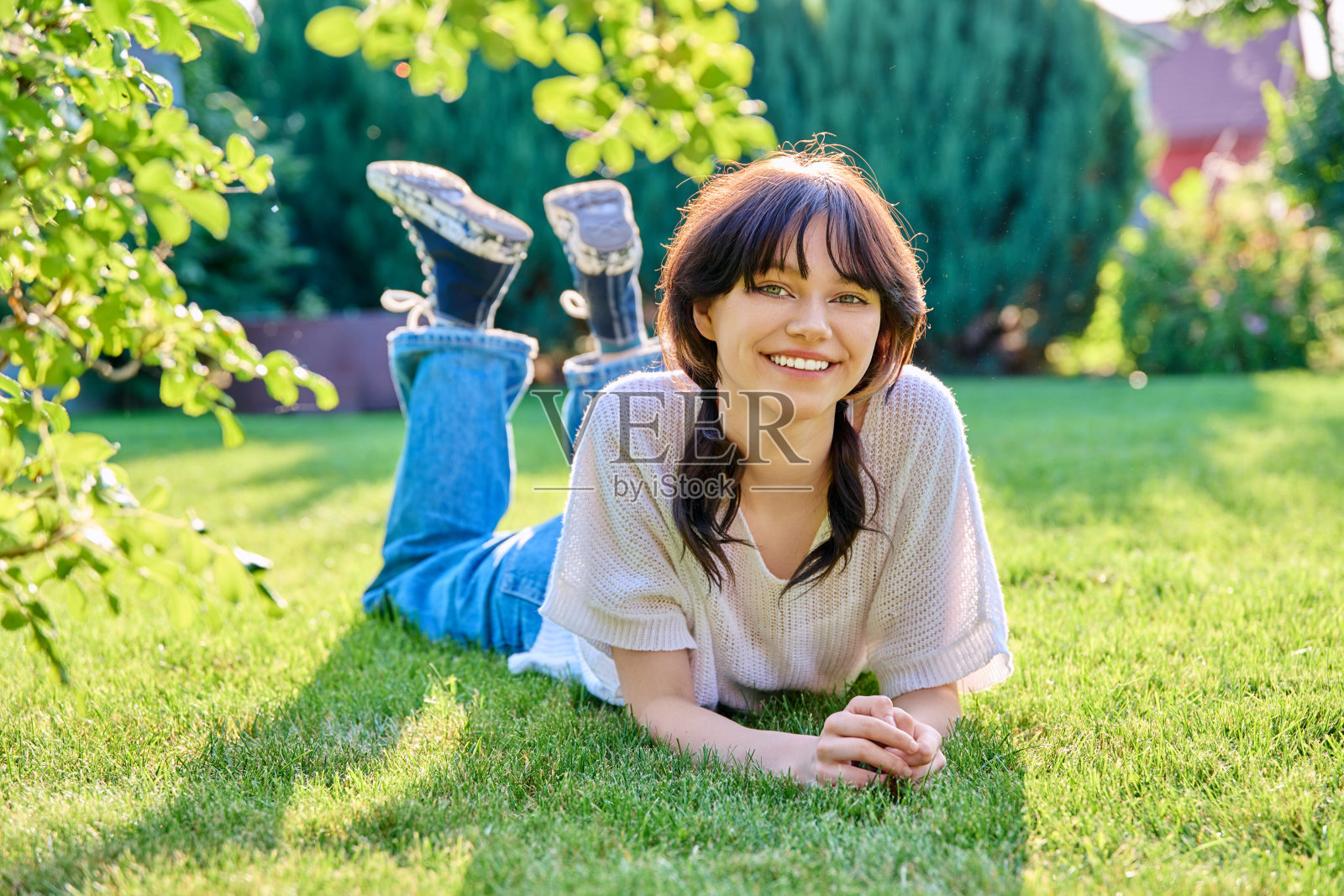 户外画像，18岁的年轻女性躺在草地上照片摄影图片