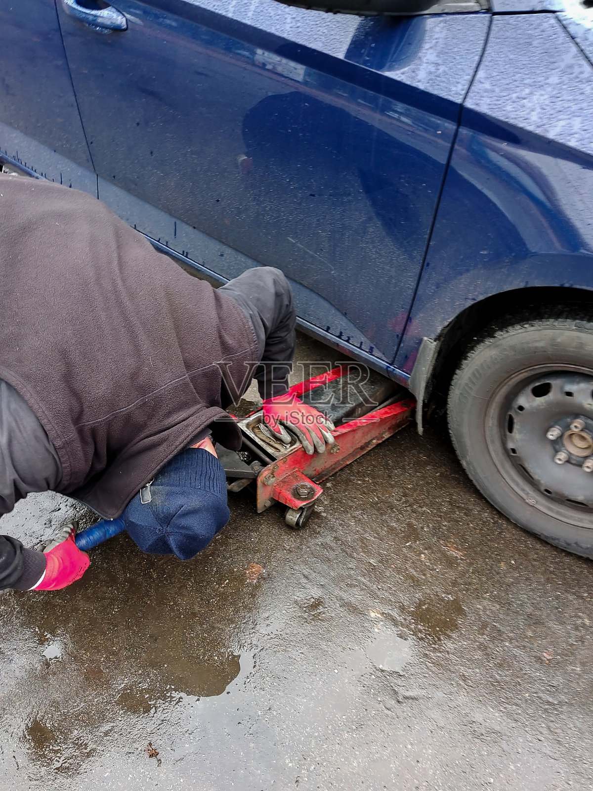 在汽车服务站给汽车千斤顶换轮子照片摄影图片