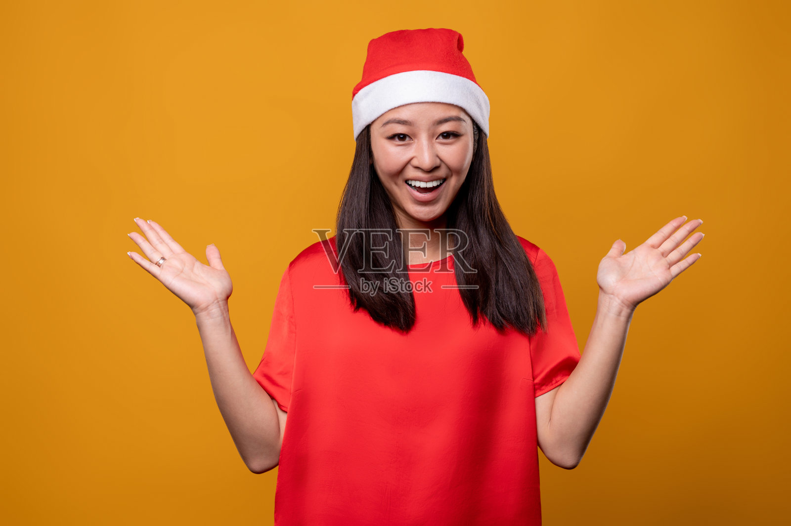 可爱的年轻女子在红色圣诞老人的帽子感觉快乐和享受照片摄影图片