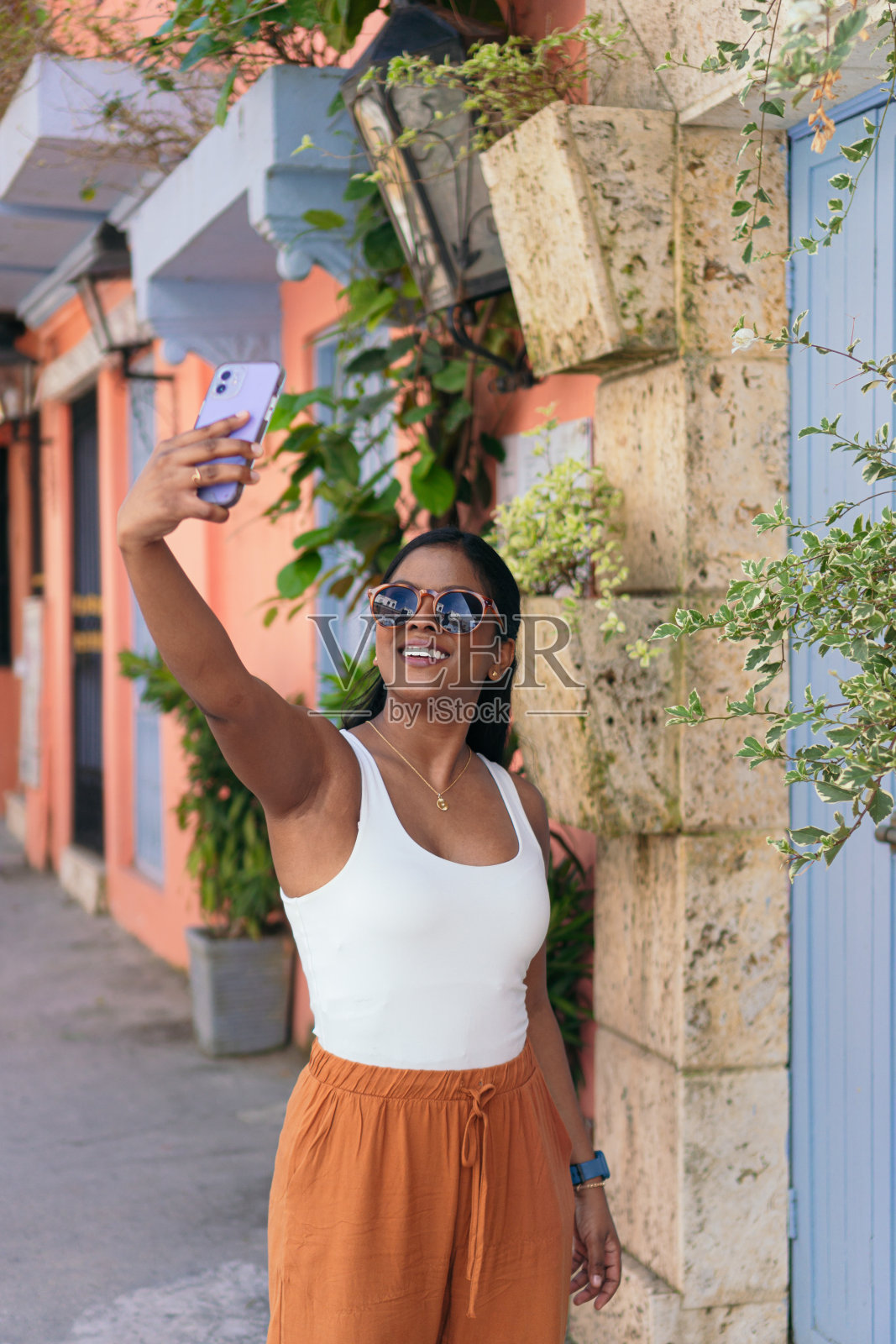 一名年轻女子在哥伦比亚卡塔赫纳的街道上拍照。照片摄影图片