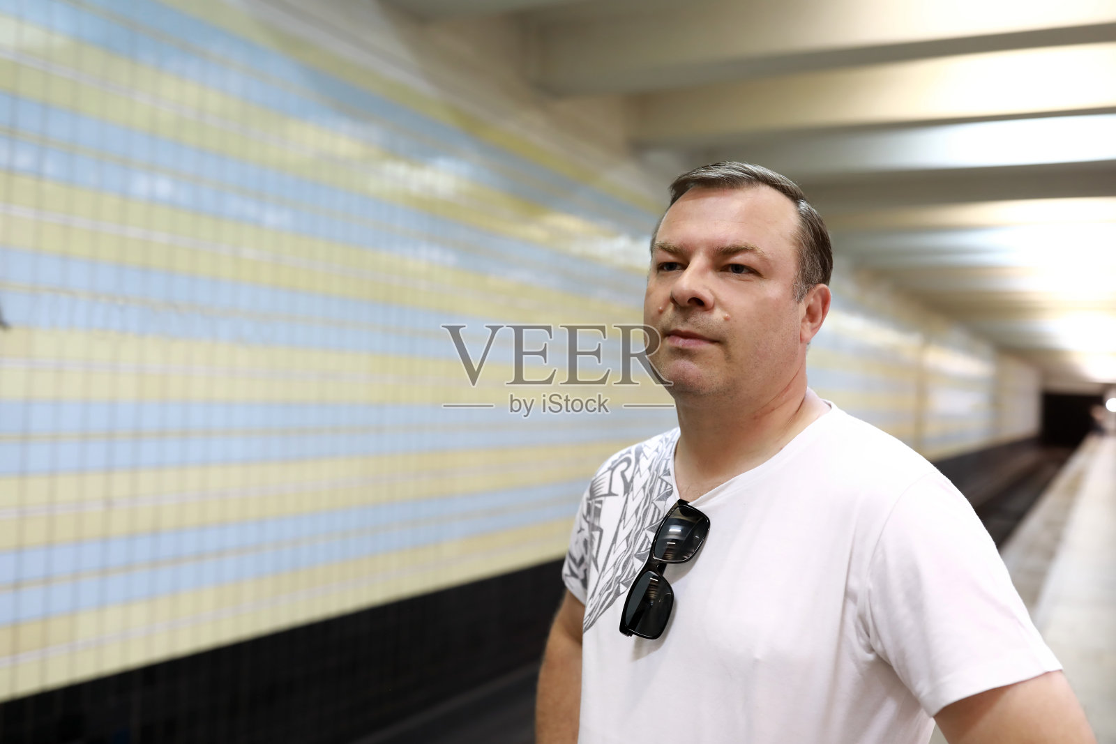 在地铁站台等车的男子照片摄影图片