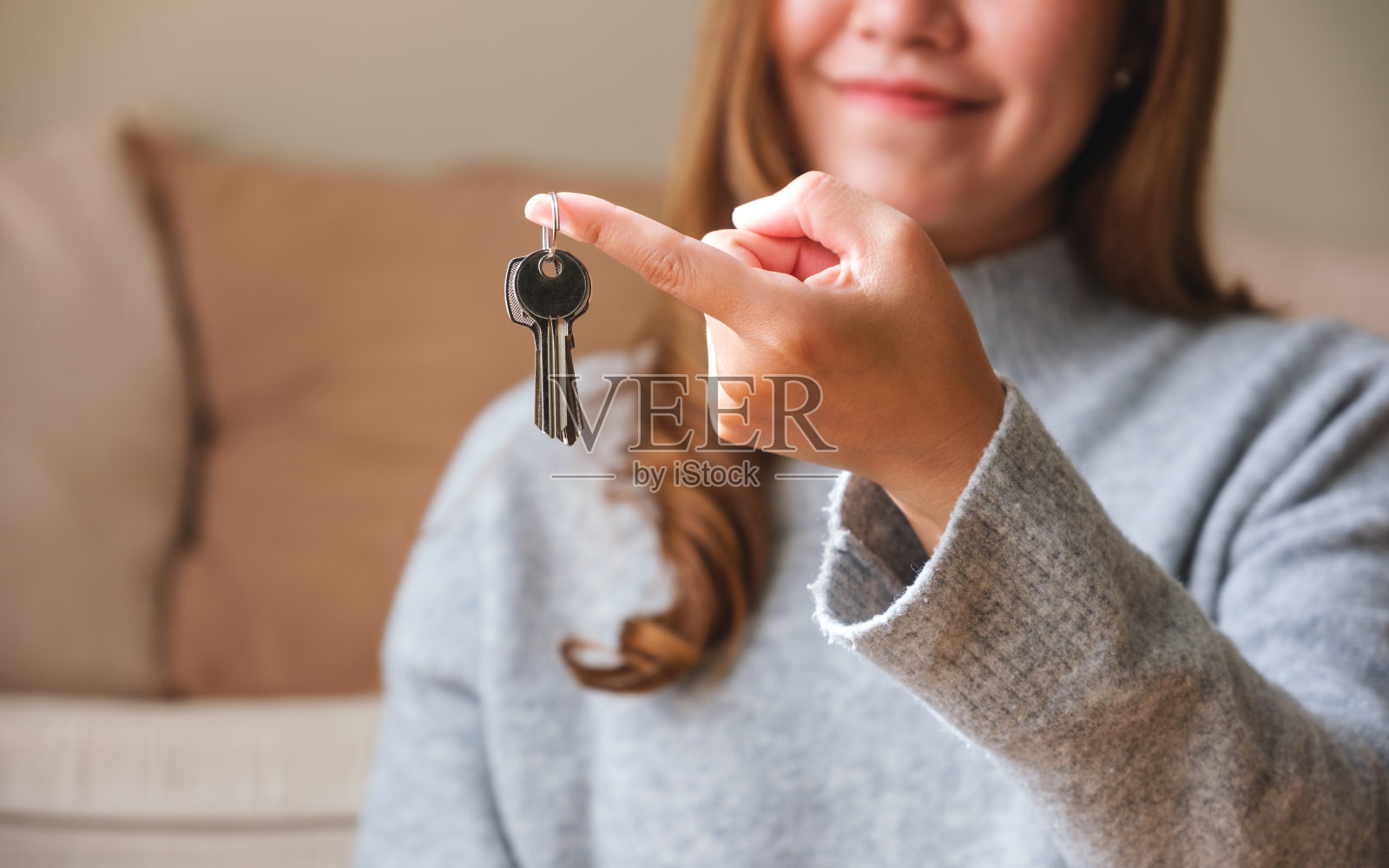 一个女人拿着房地产概念的钥匙的特写图像照片摄影图片