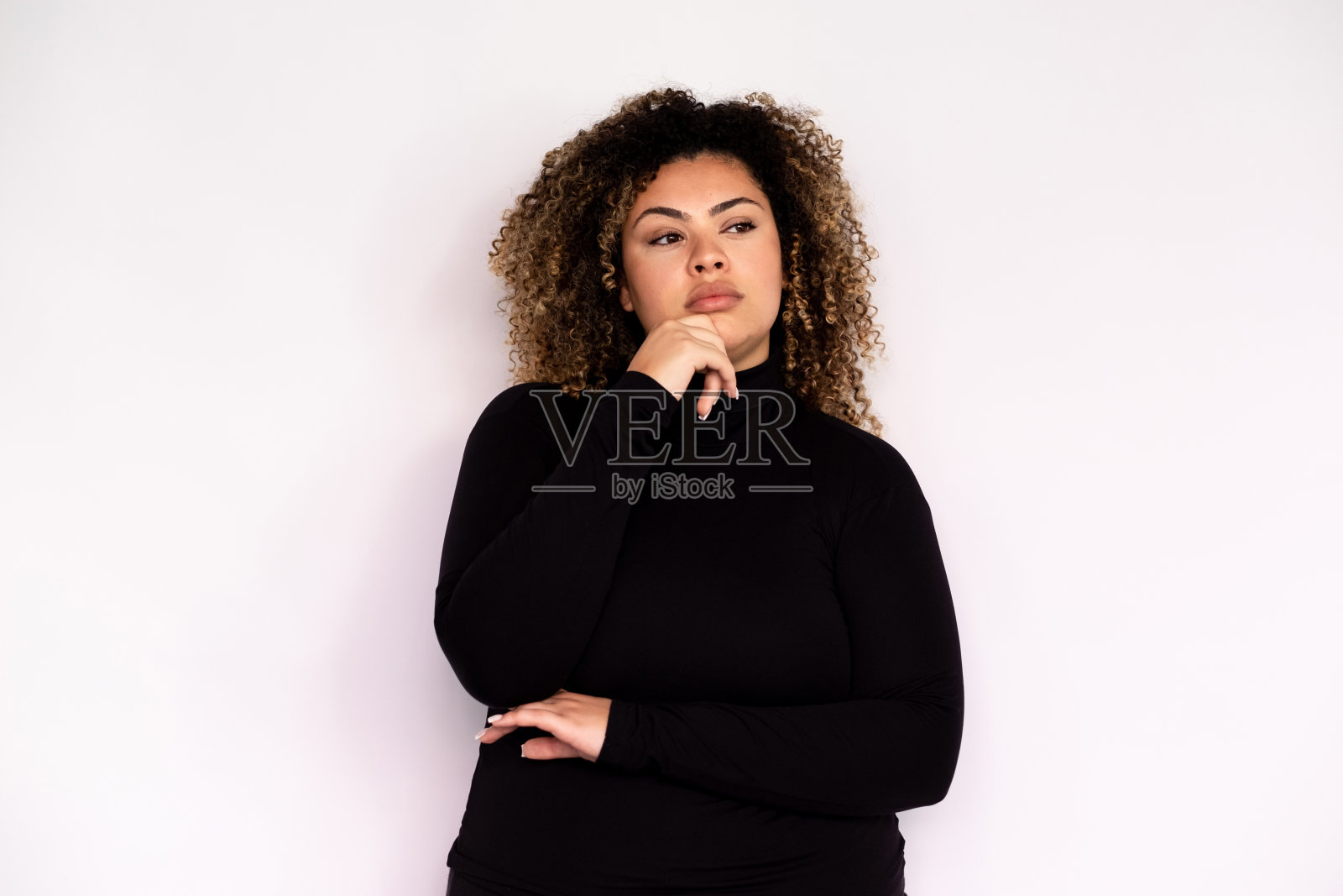 沉思的年轻女子手放在下巴看向别处照片摄影图片