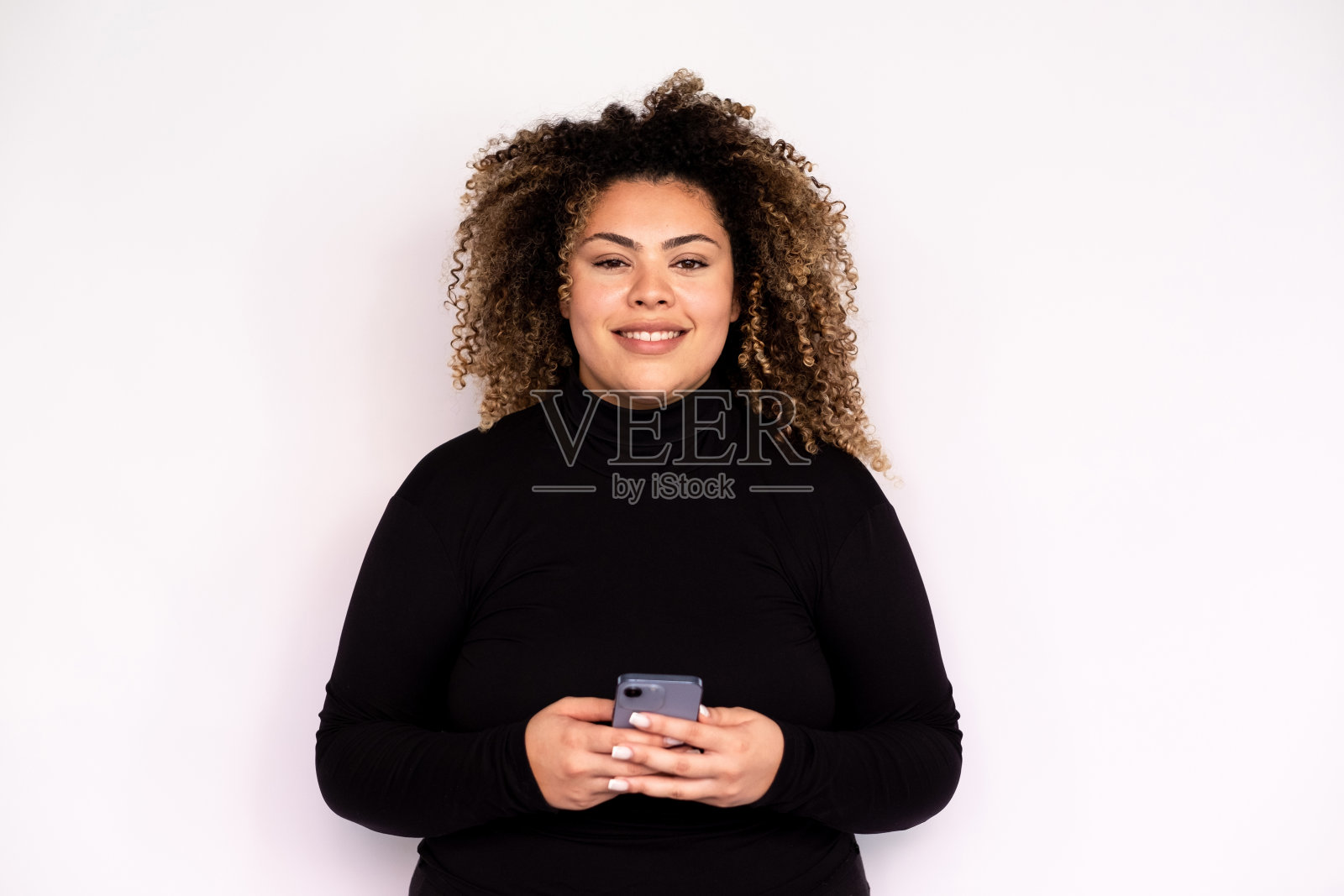 快乐的年轻女子，手里拿着智能手机照片摄影图片