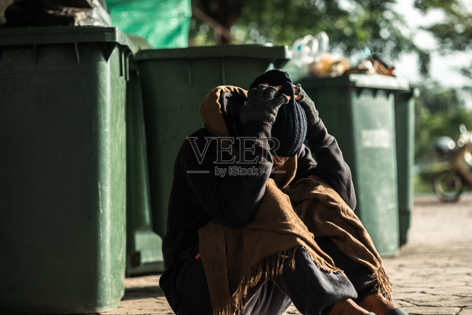 在阴影城市中疲惫沮丧的无家可归者等待帮助照片摄影图片