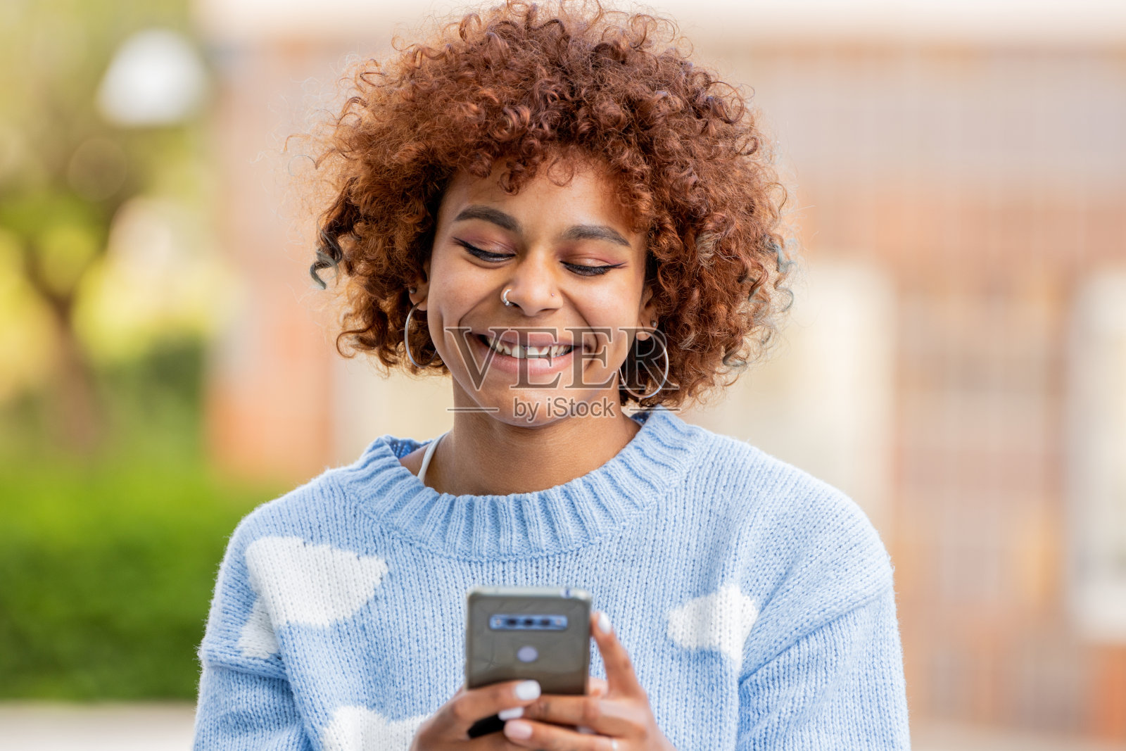 一个非裔美国女孩在街上拿着手机照片摄影图片
