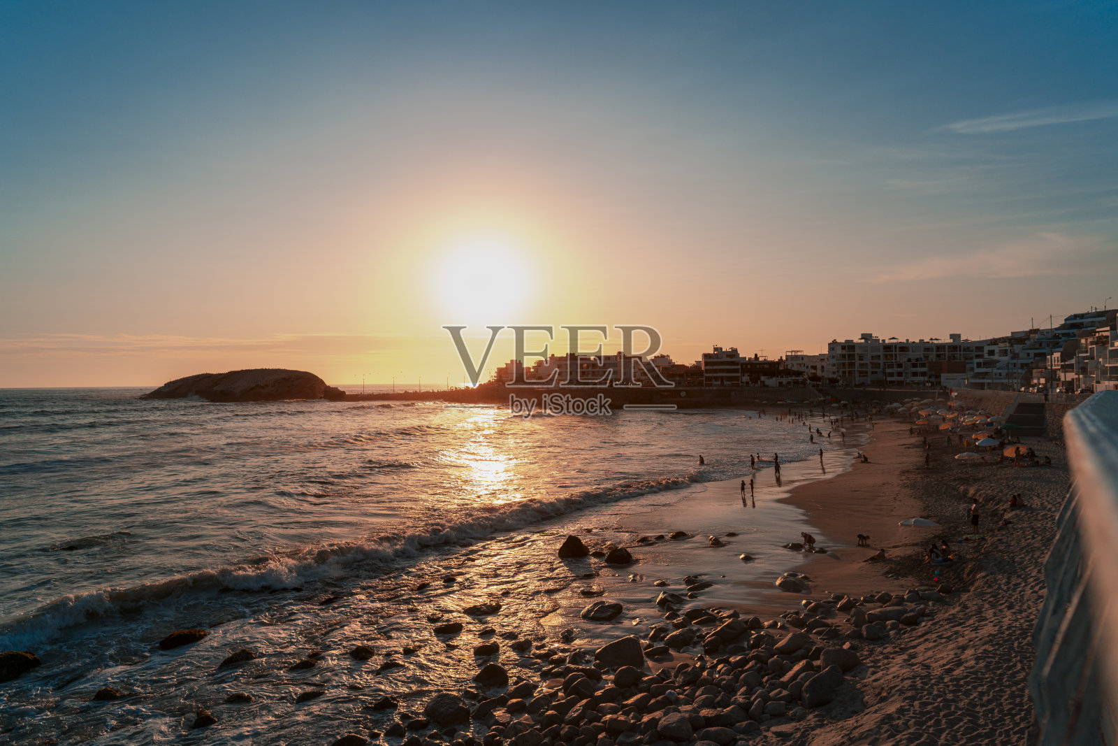 在秘鲁利马蓬塔赫莫萨海滩上的蓝天上，夕阳在沙滩上照片摄影图片