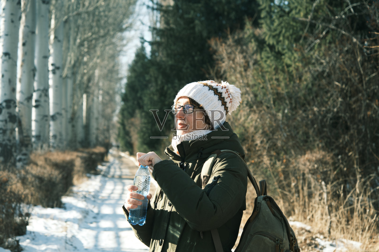 女子在冬季公园里喝水照片摄影图片