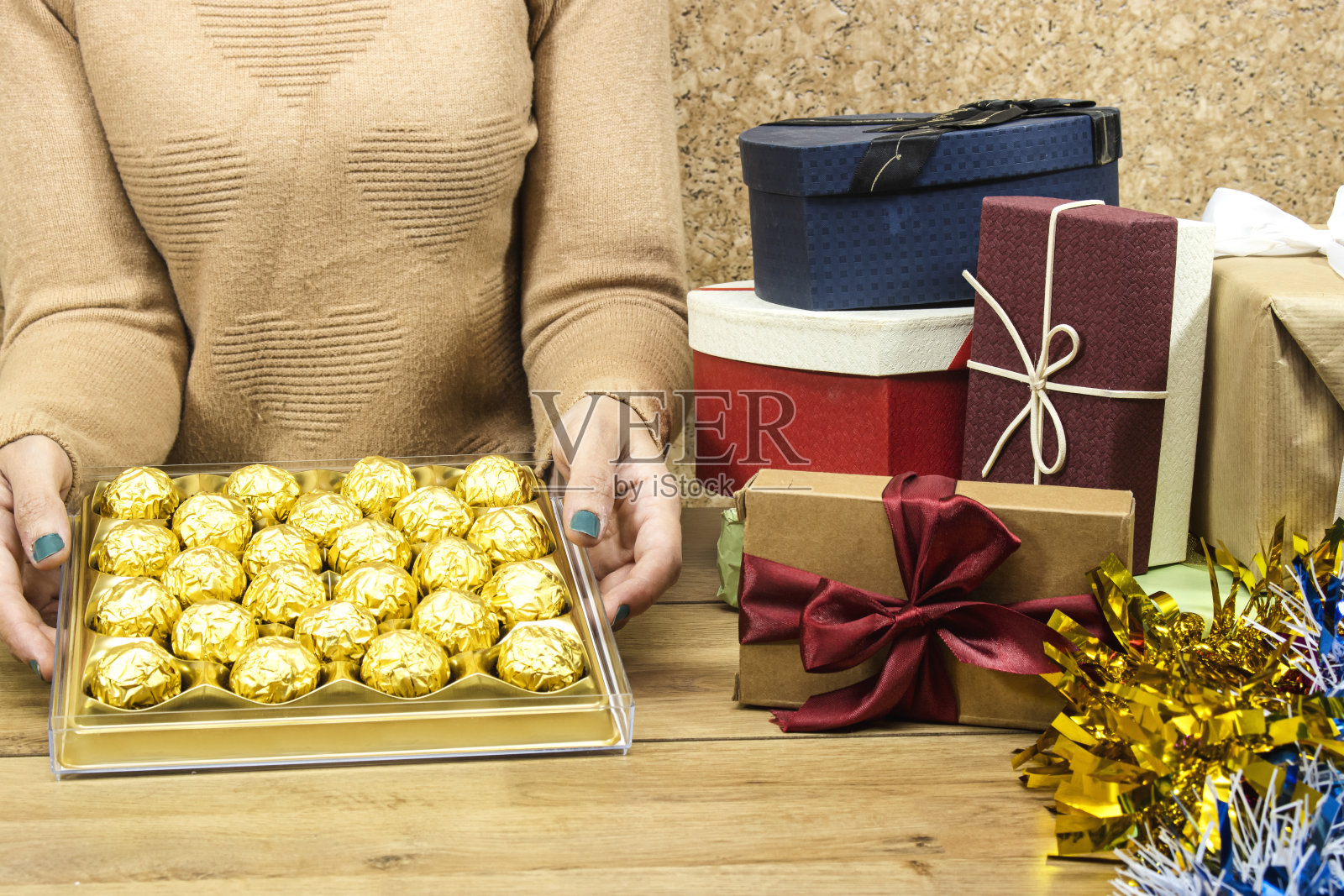 圣诞节或新年假期的概念，礼品盒与金箔上的木桌和女人手礼品或礼品盒的黄金高级巧克力照片摄影图片