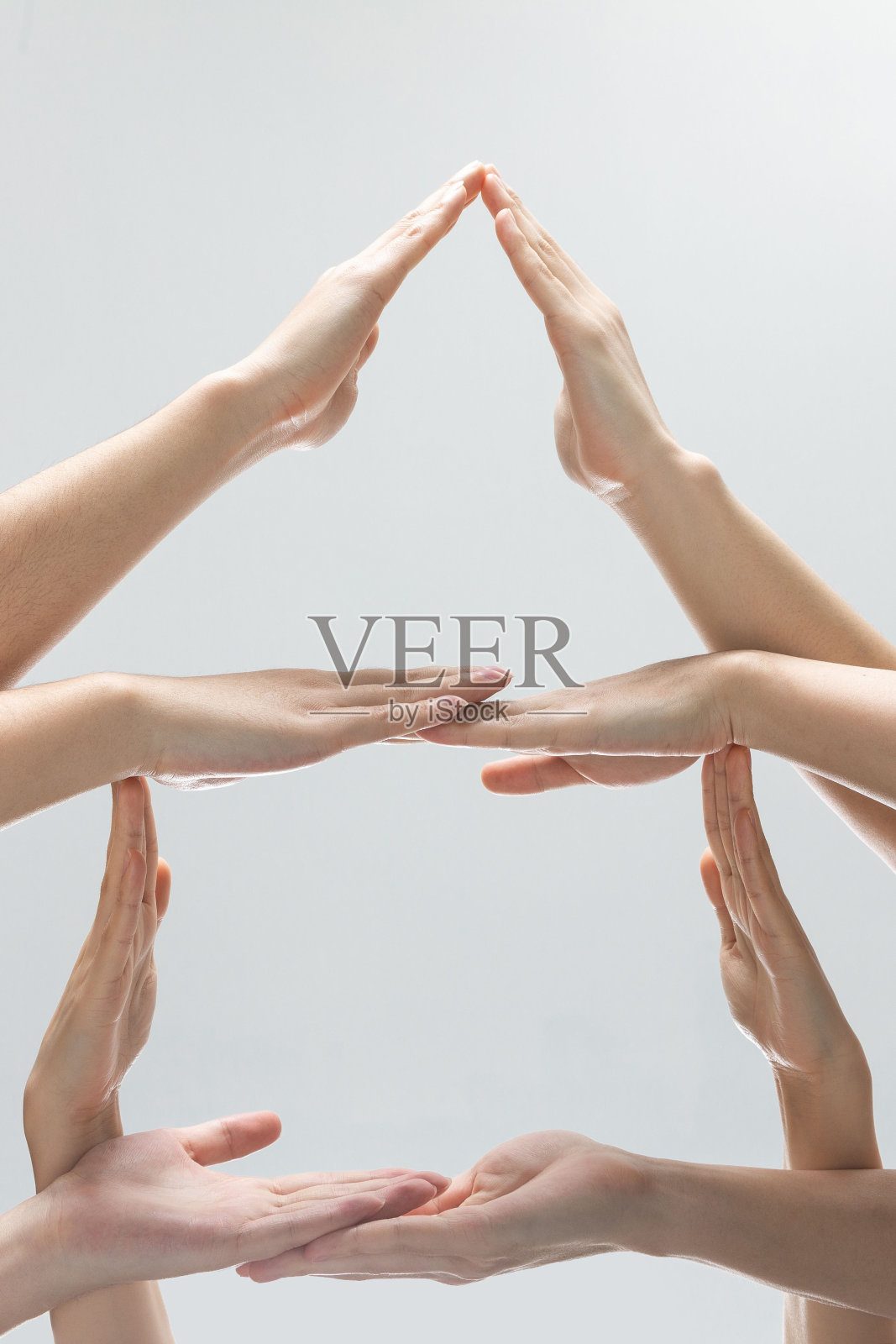 垂直拍摄的帮助手在灰色背景前做一个金字塔照片摄影图片