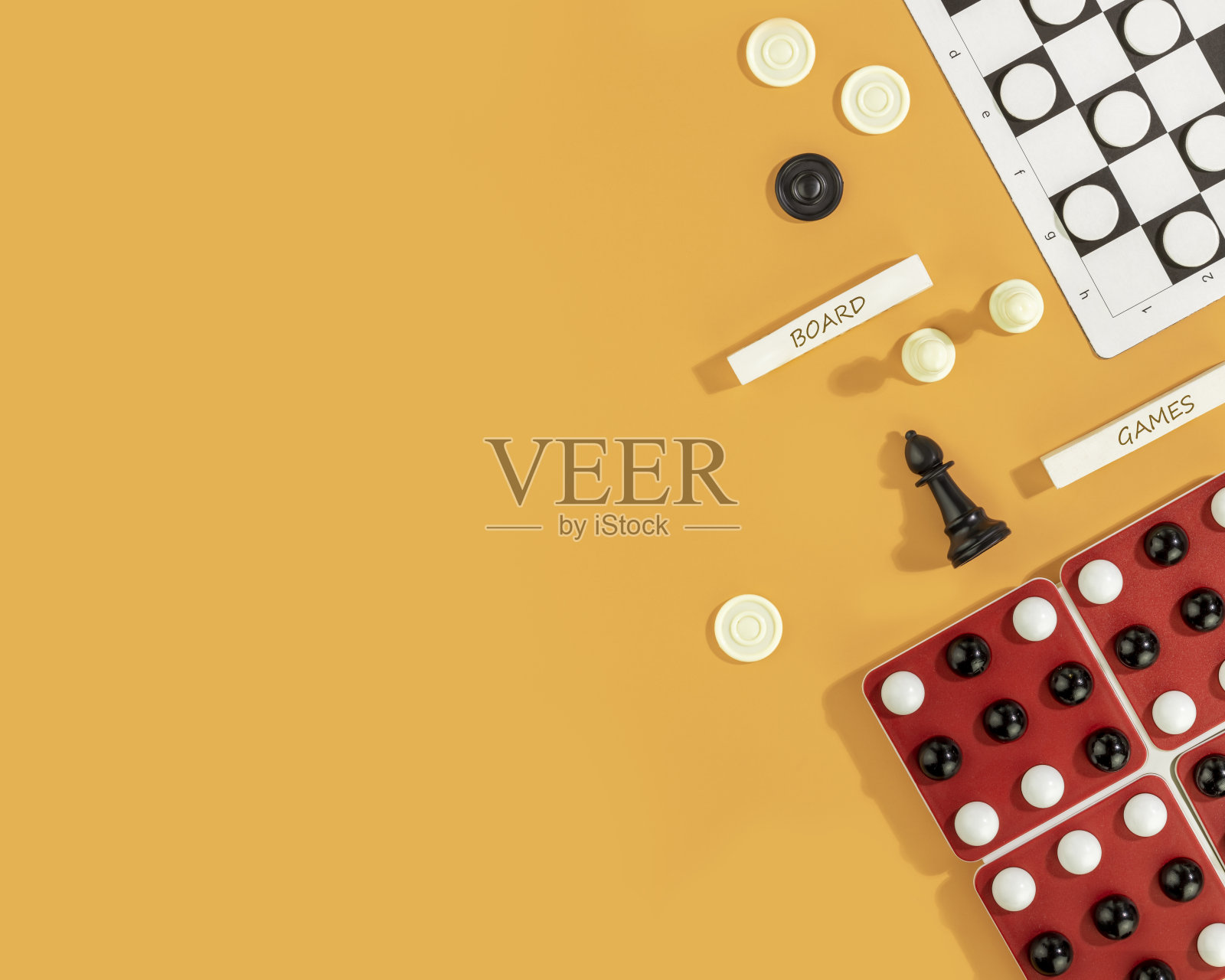 各种各样的棋盘游戏在橙色的背景与圣诞装饰照片摄影图片