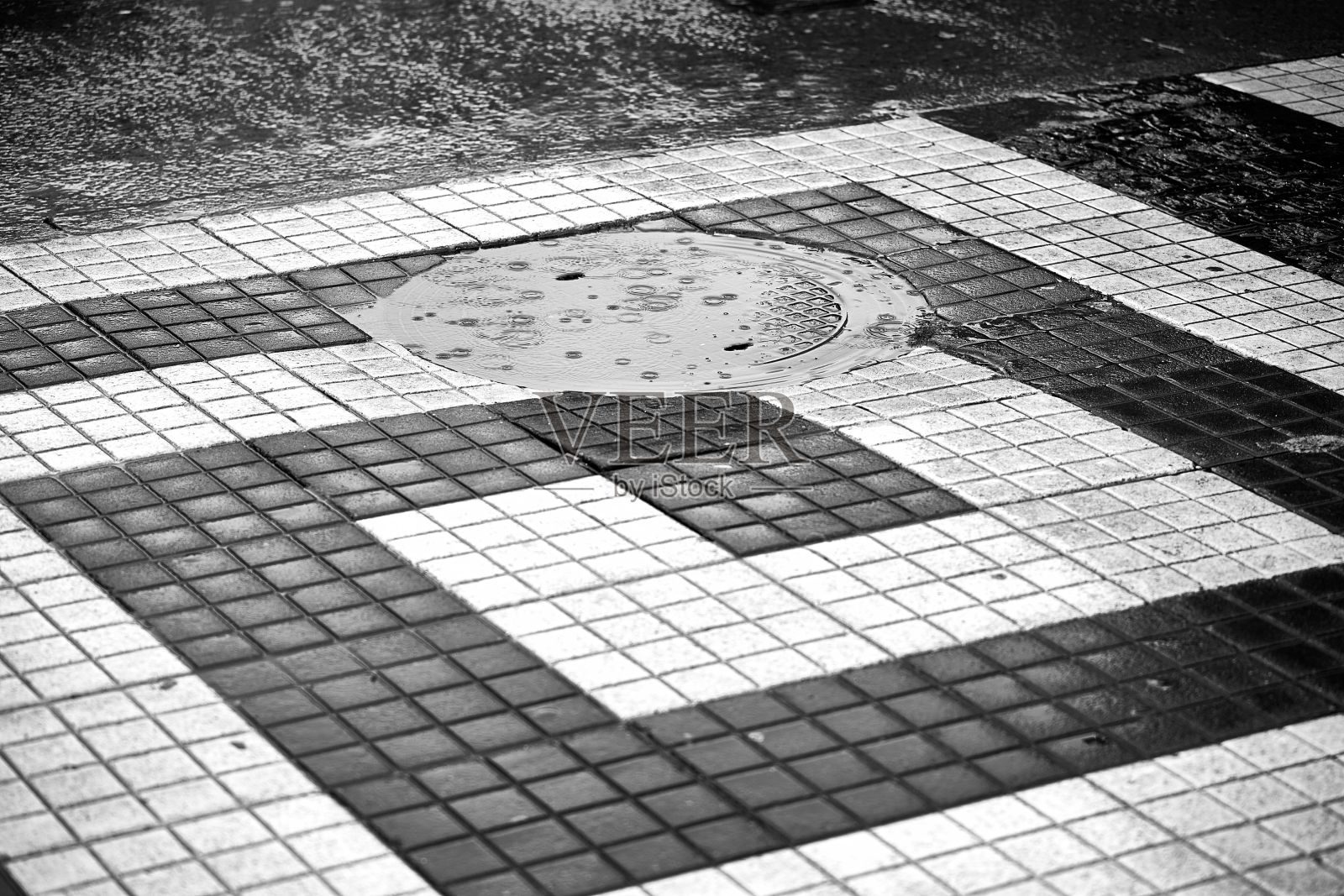 在瑞典斯德哥尔摩，雨滴落在地上的灰度镜头。照片摄影图片