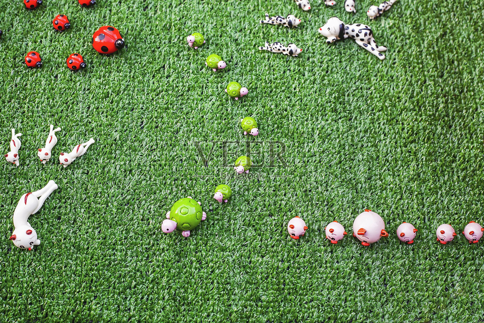 人造草地上的小动物陶瓷雕像，俯视图照片摄影图片