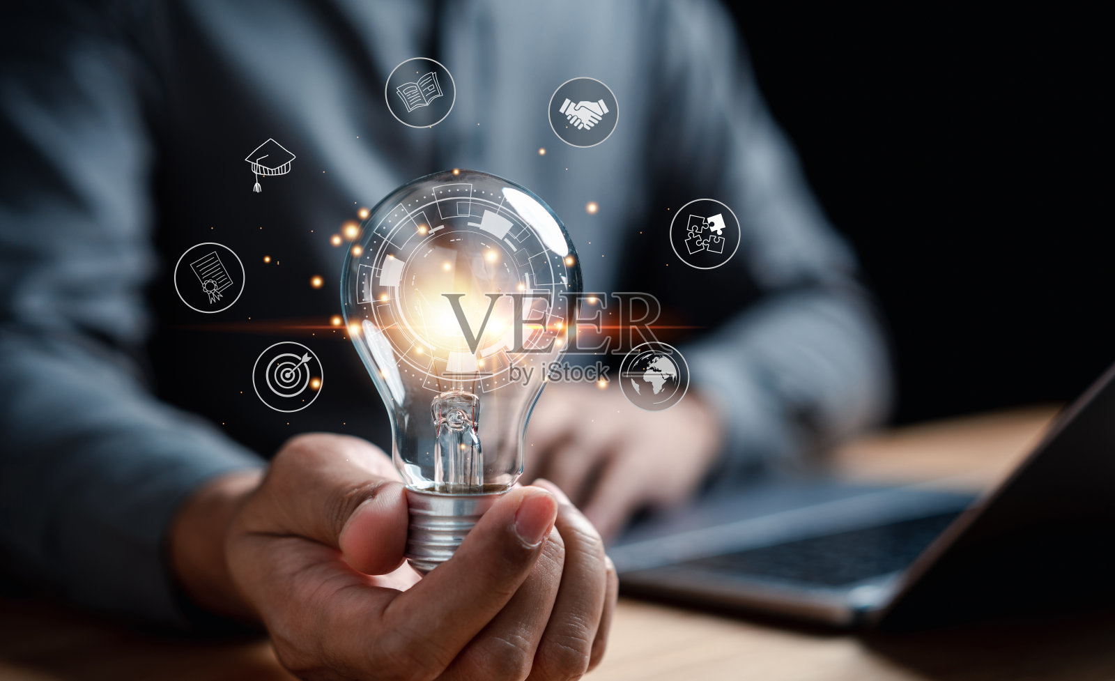 手持灯泡的男人与学习教育毕业概念照片摄影图片