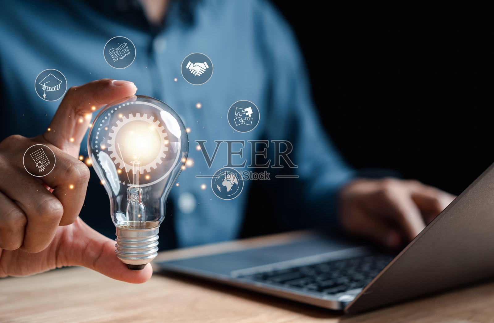 手持灯泡的男人与学习教育毕业概念照片摄影图片