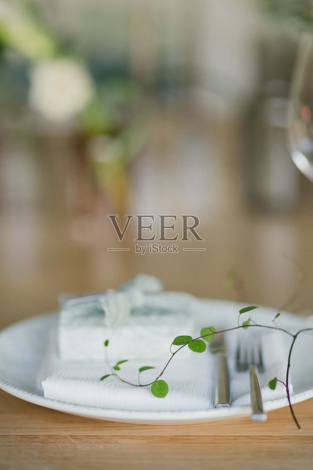 婚宴的餐桌布置。有美丽的花朵和绿色植物的花卉作品，蜡烛，装饰好的桌子上的摆设和盘子。照片摄影图片