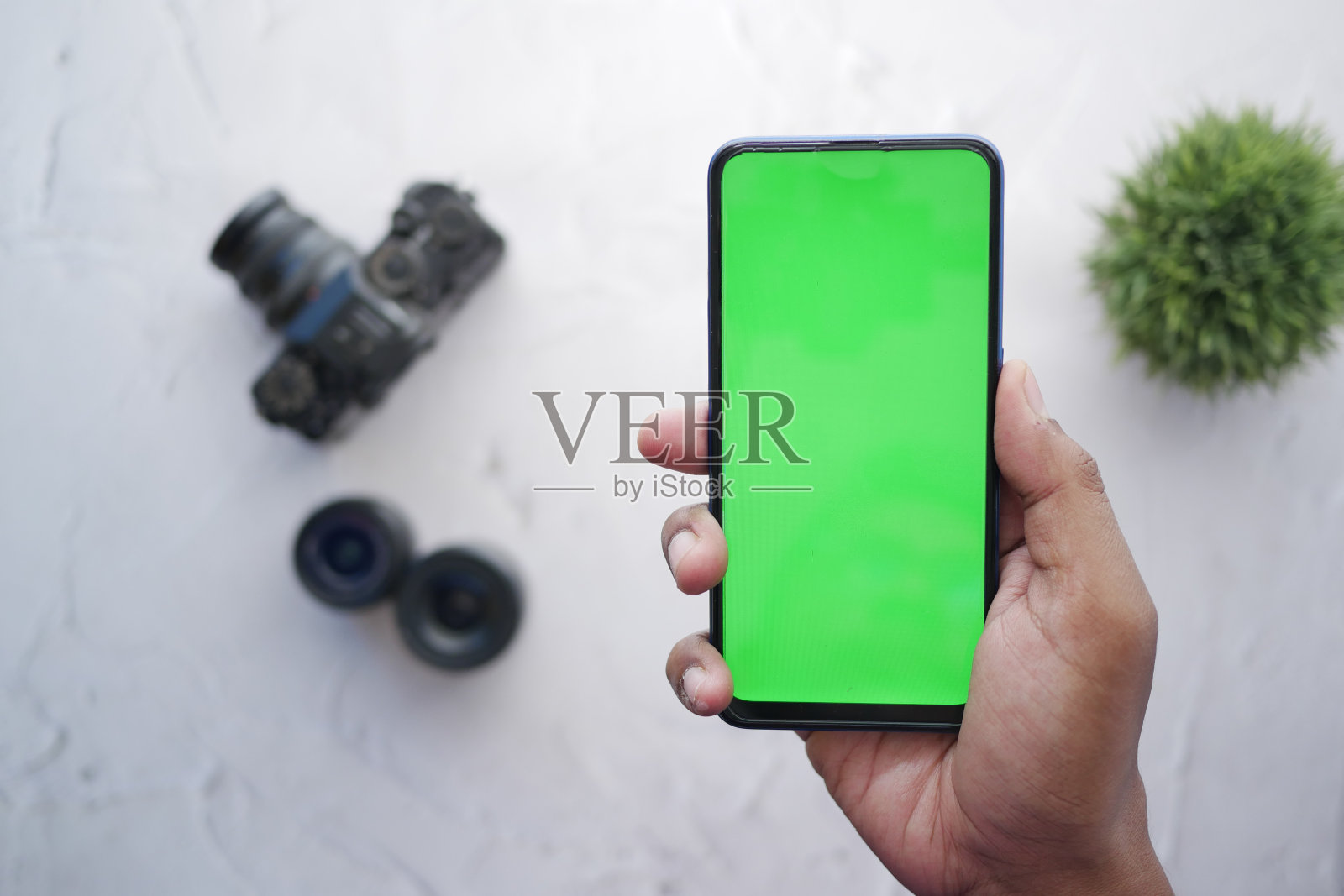 手持绿色屏幕和背景摄像头的智能手机的俯视图照片摄影图片