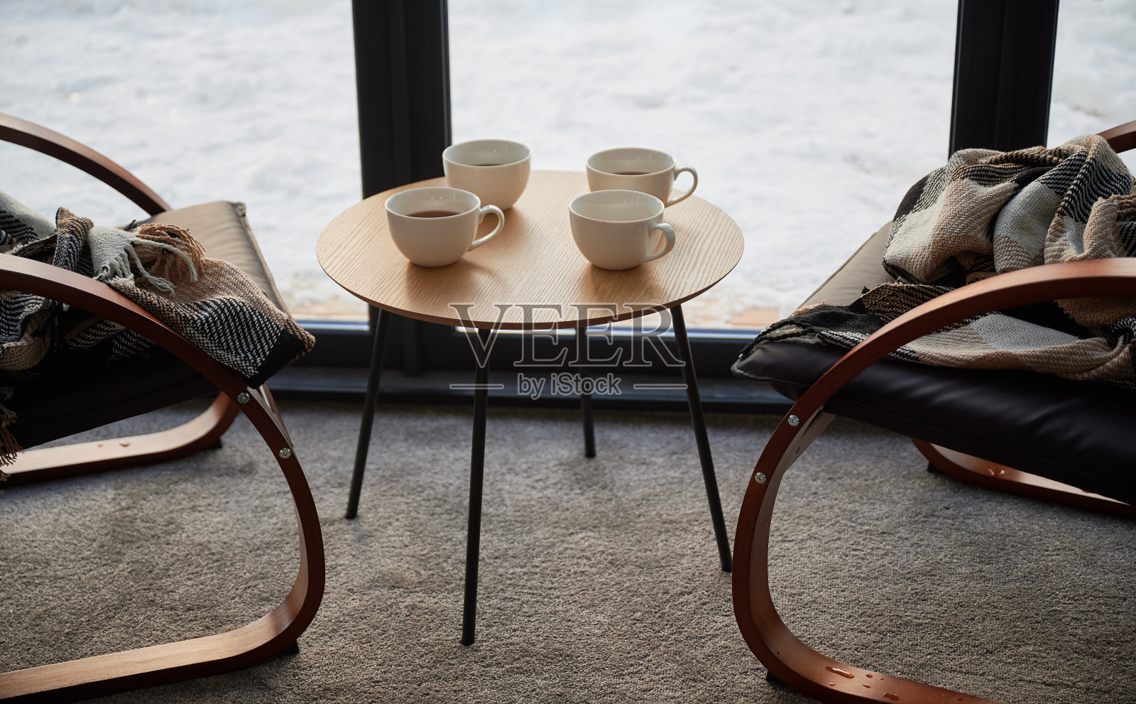 四杯茶放在咖啡馆里的小桌子上，舒适的格子椅上。照片摄影图片