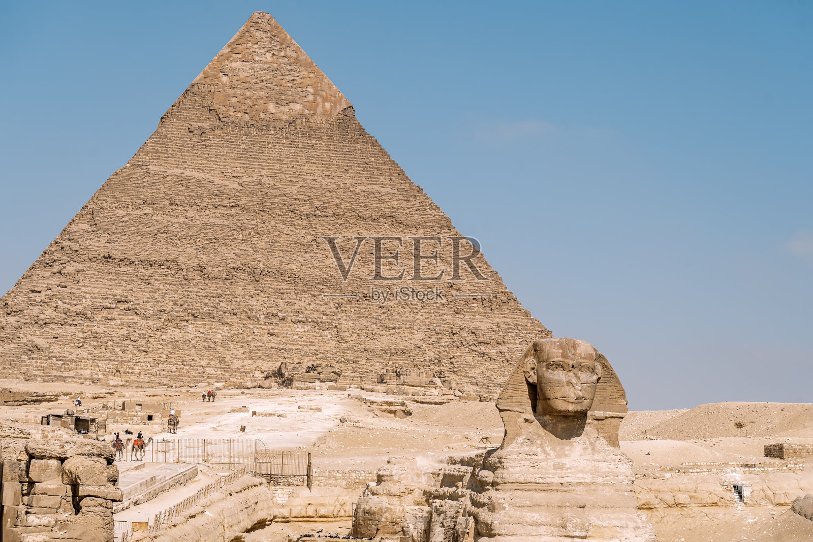 吉萨尼罗河西岸的大狮身人面像是古老的纪念雕塑。它是由整块石灰石岩石雕刻而成，呈巨大的狮身人面像——狮子躺在沙滩上照片摄影图片