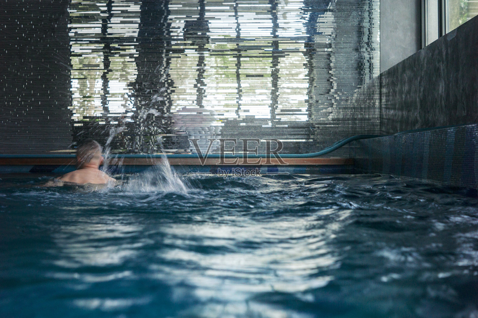 游泳池里的男人照片摄影图片