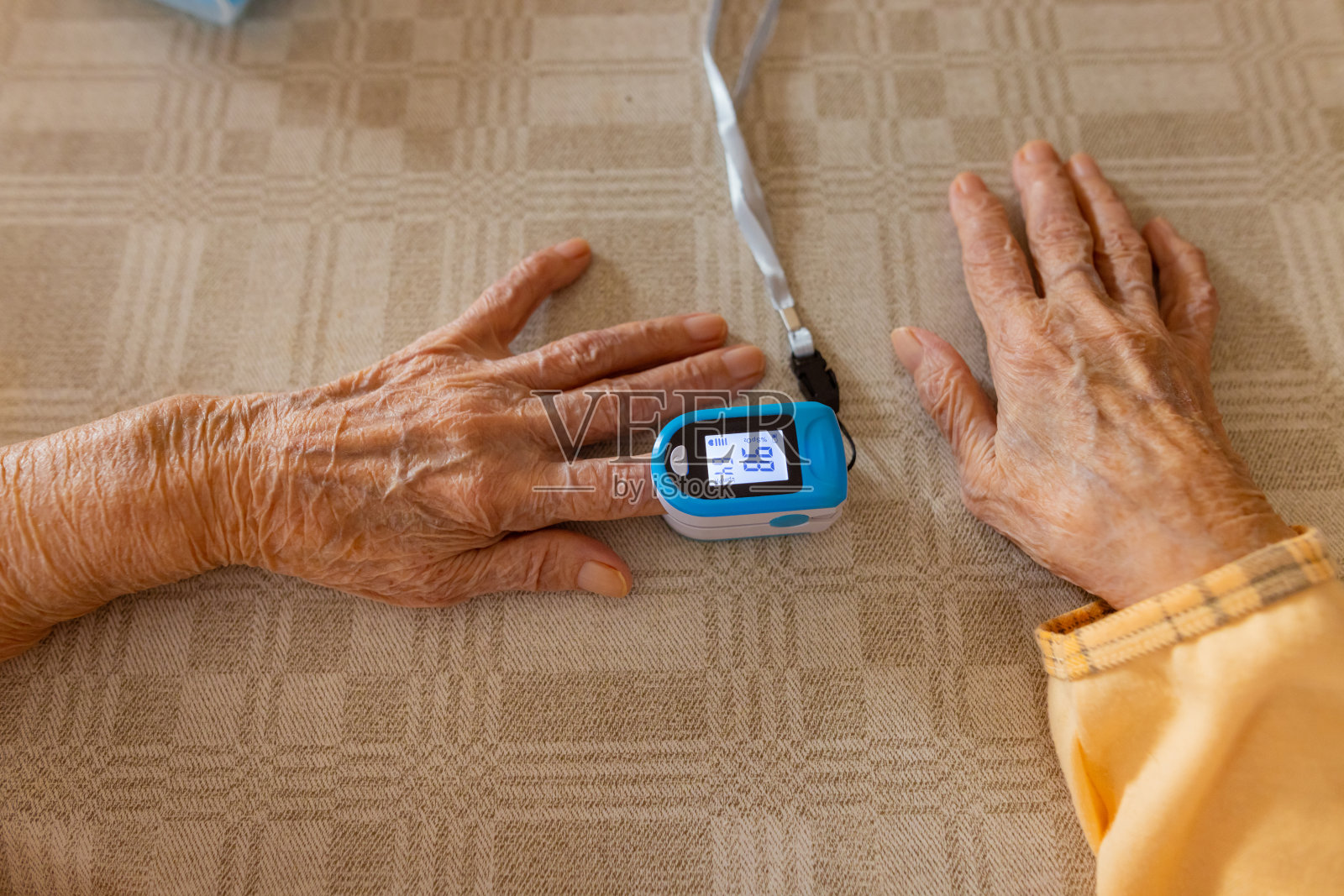 老年妇女在家里用仪器控制她的胰岛素照片摄影图片