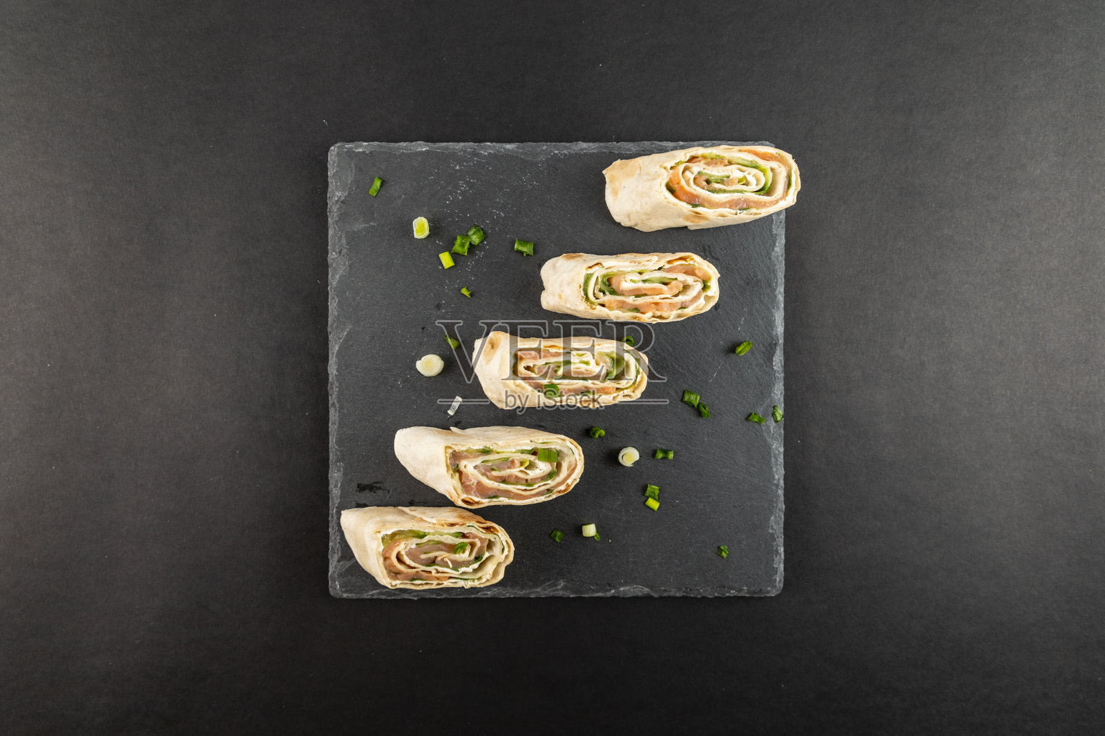 拉瓦什玉米饼小吃与奶油芝士烟熏鲑鱼和黄瓜石板石板盘与洋葱装饰照片摄影图片