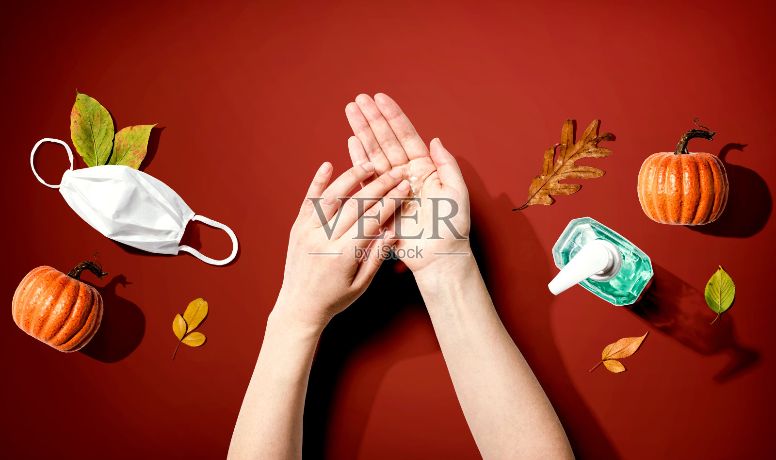 在秋天的南瓜和叶子上涂抹消毒凝胶照片摄影图片