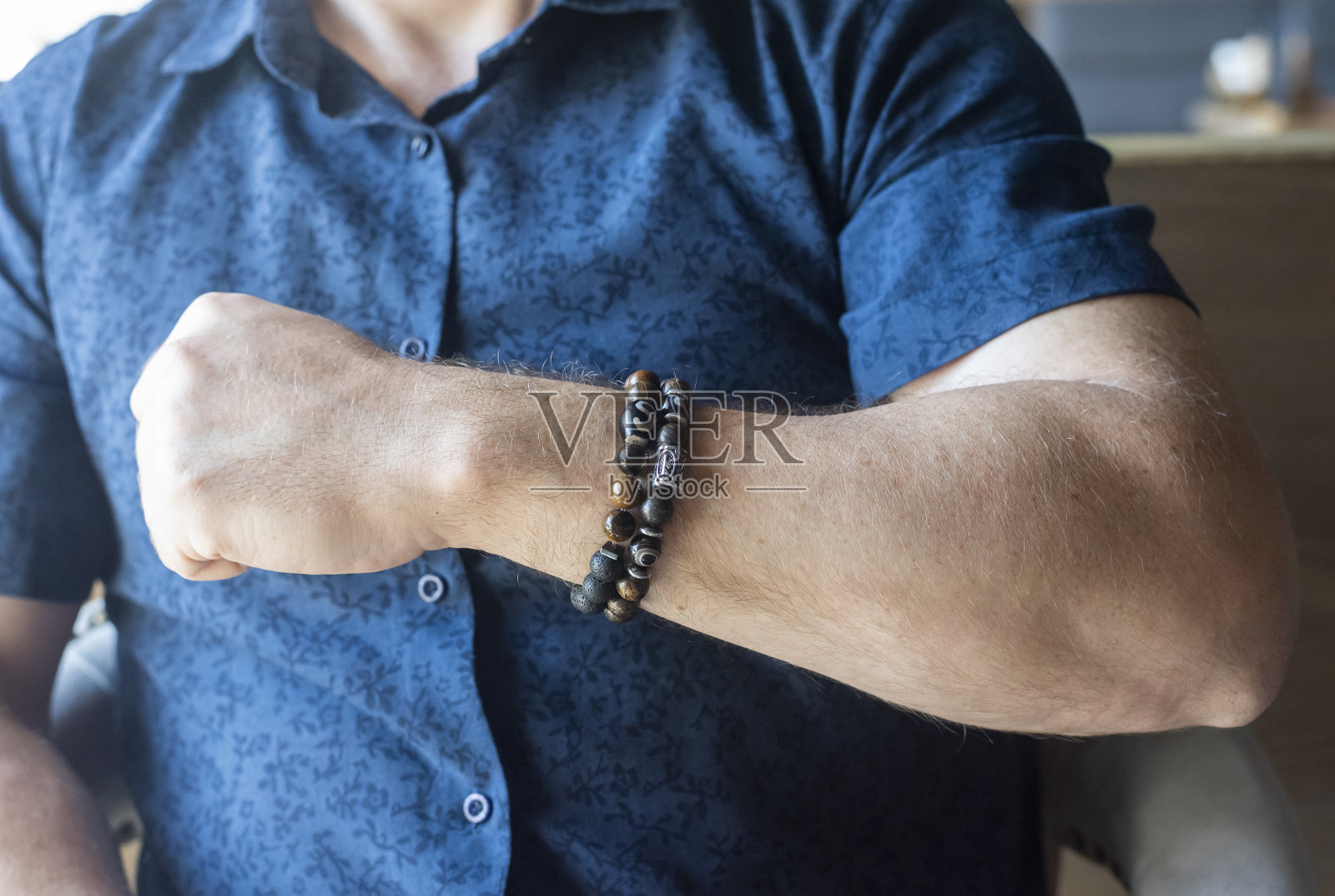 在自然光下戴在男人手上的石头做成的手镯照片摄影图片