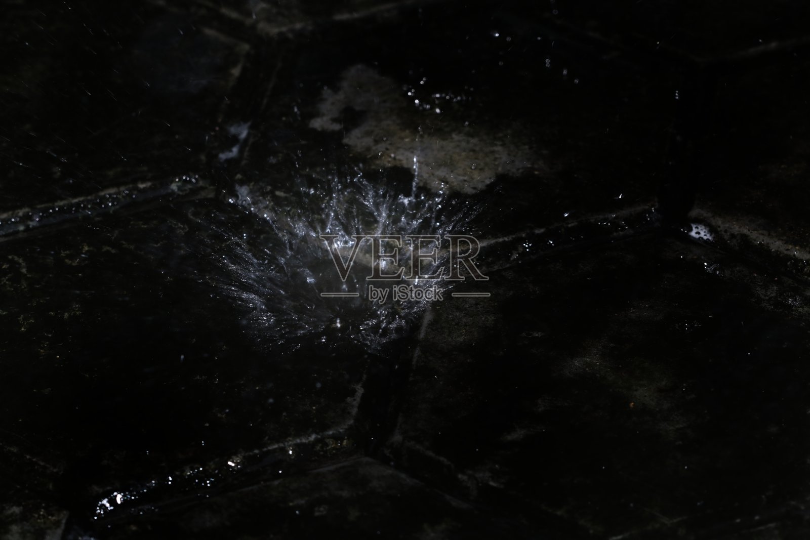 下雨时，水溅在地板上形成圆形图案。照片摄影图片