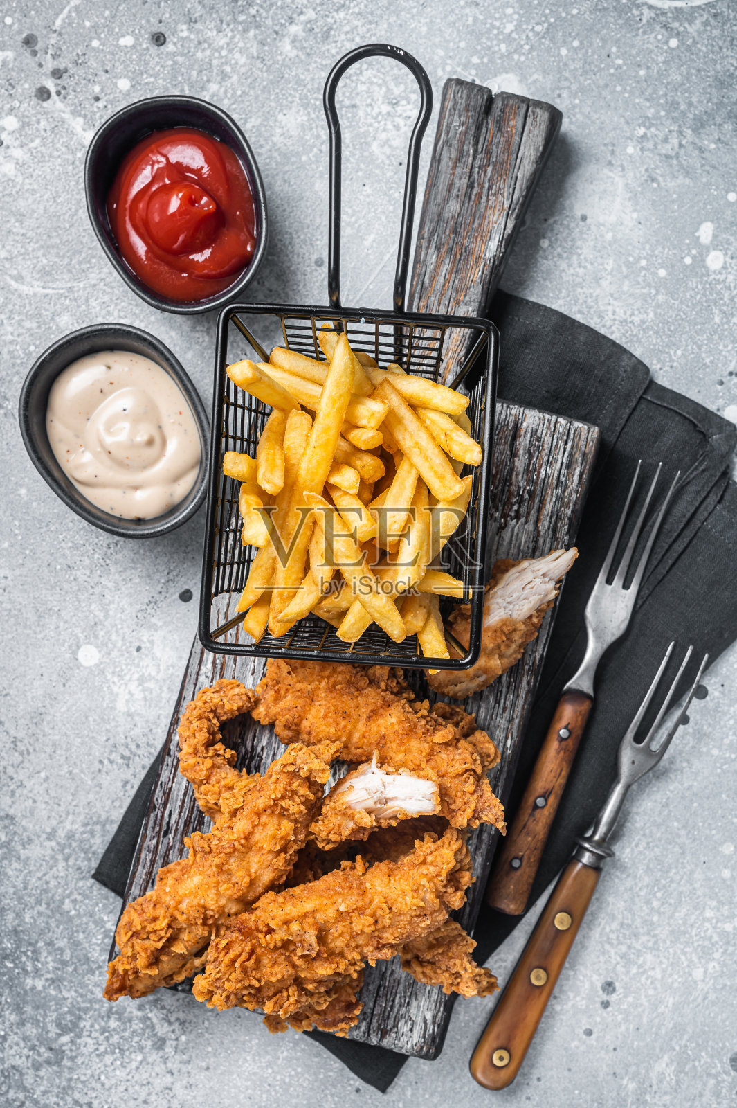 面包鸡条配炸薯条和番茄酱。灰色backgrund。俯视图照片摄影图片