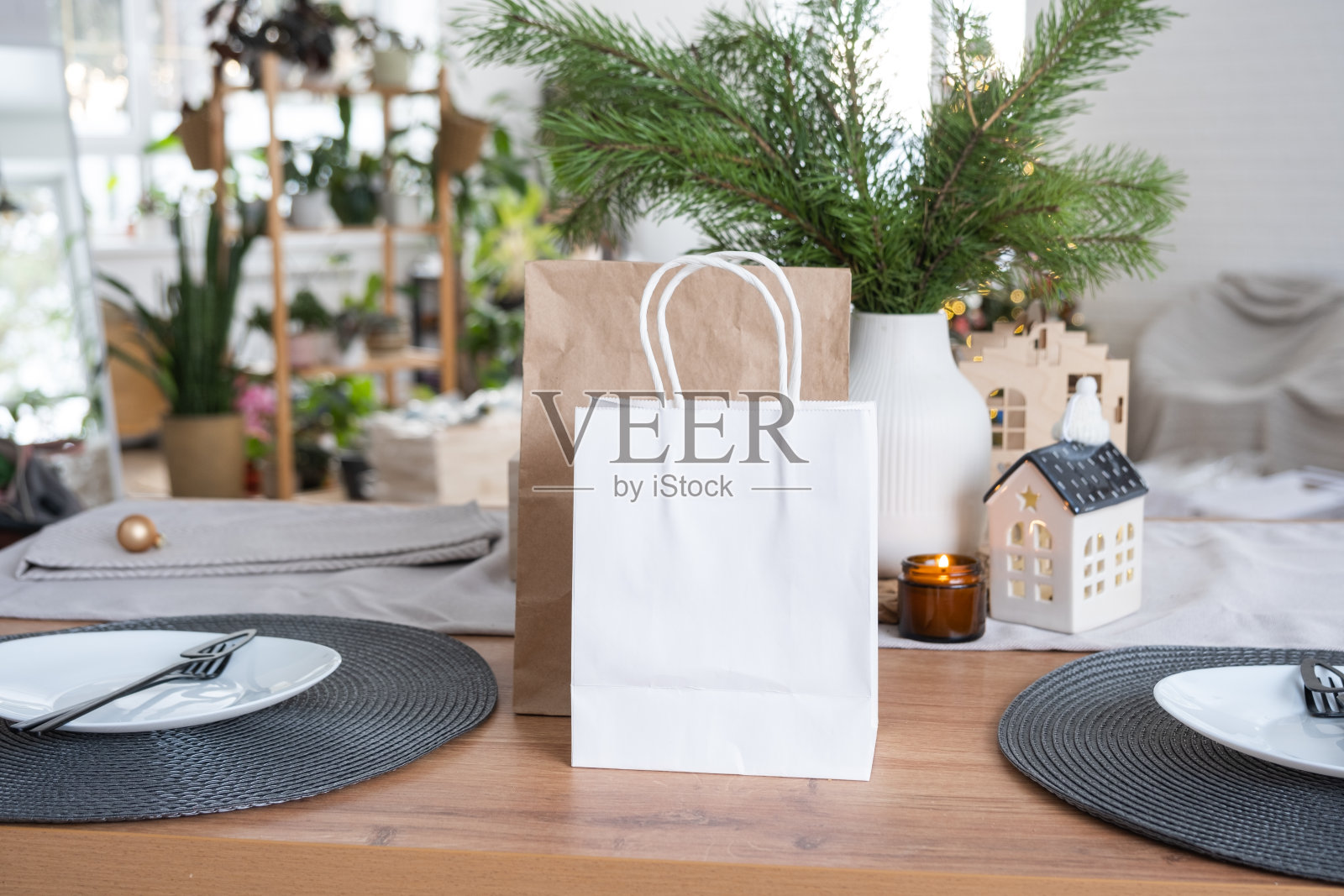 为圣诞节装饰的厨房餐桌上摆放着模拟的纸包。购物和礼物，礼物和即食食品都是为新年准备的照片摄影图片