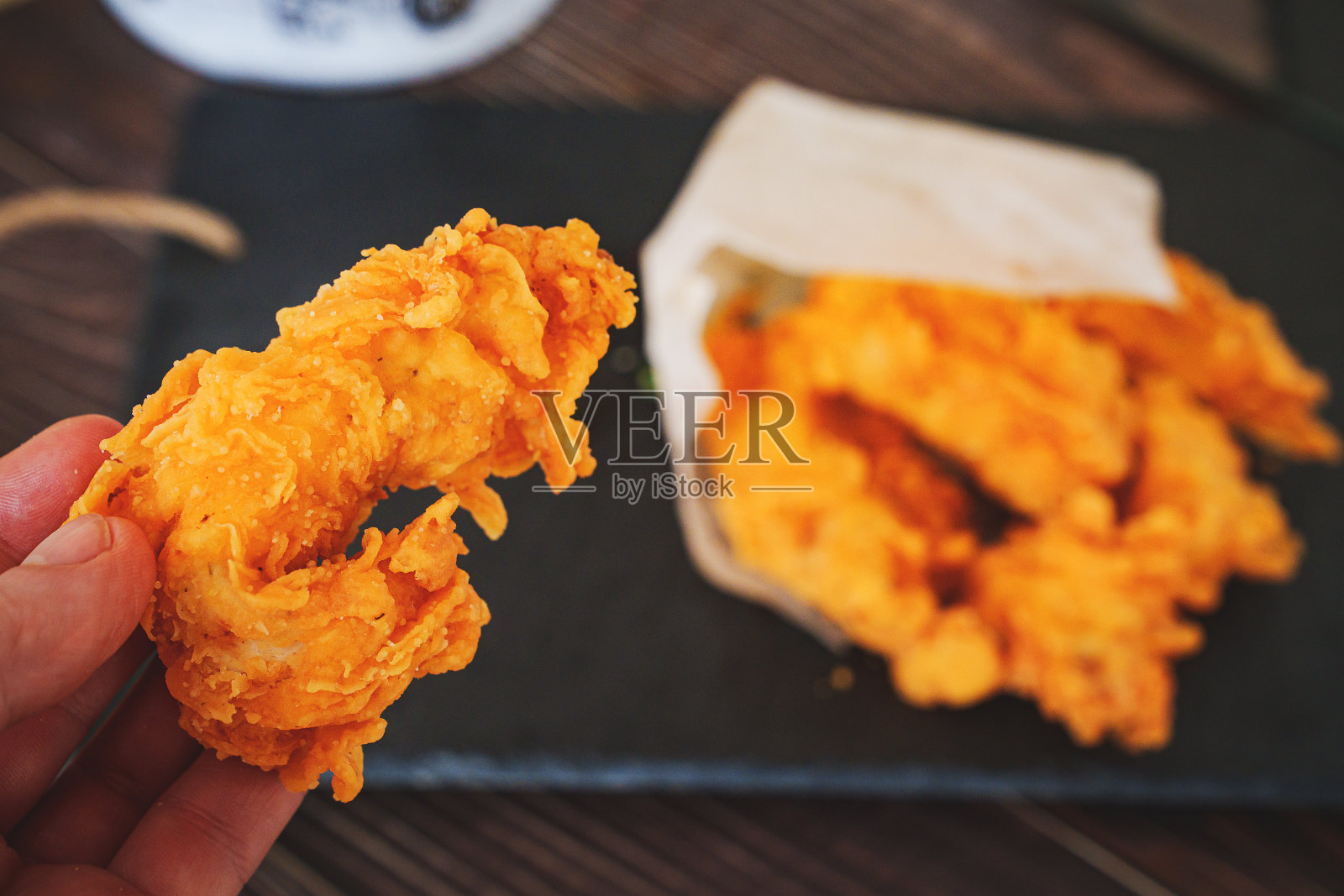 手臂和肉条放在黑色托盘上。用面包片炸过的肉条。照片摄影图片