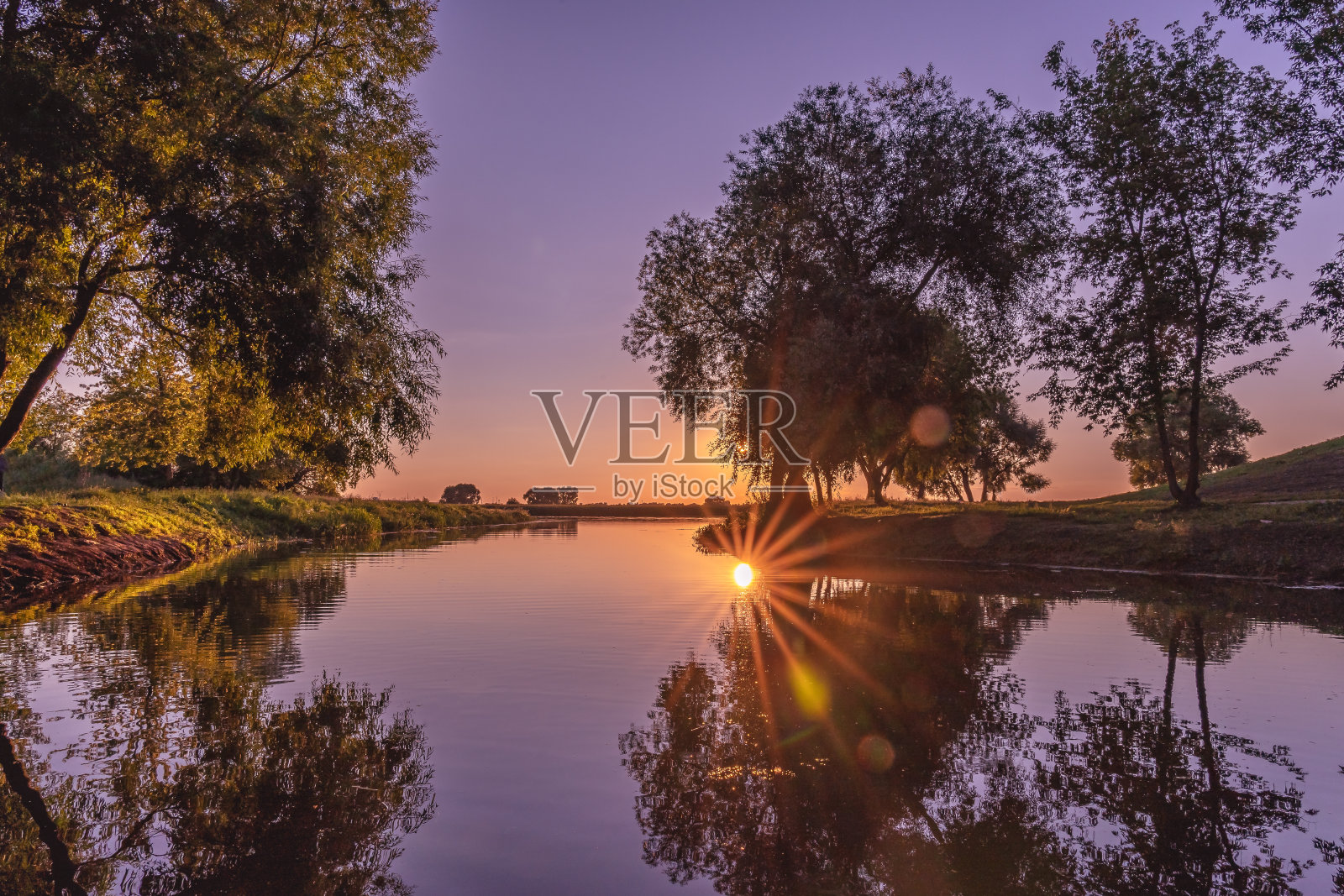 日落时太阳和自然在河上的倒影。照片摄影图片