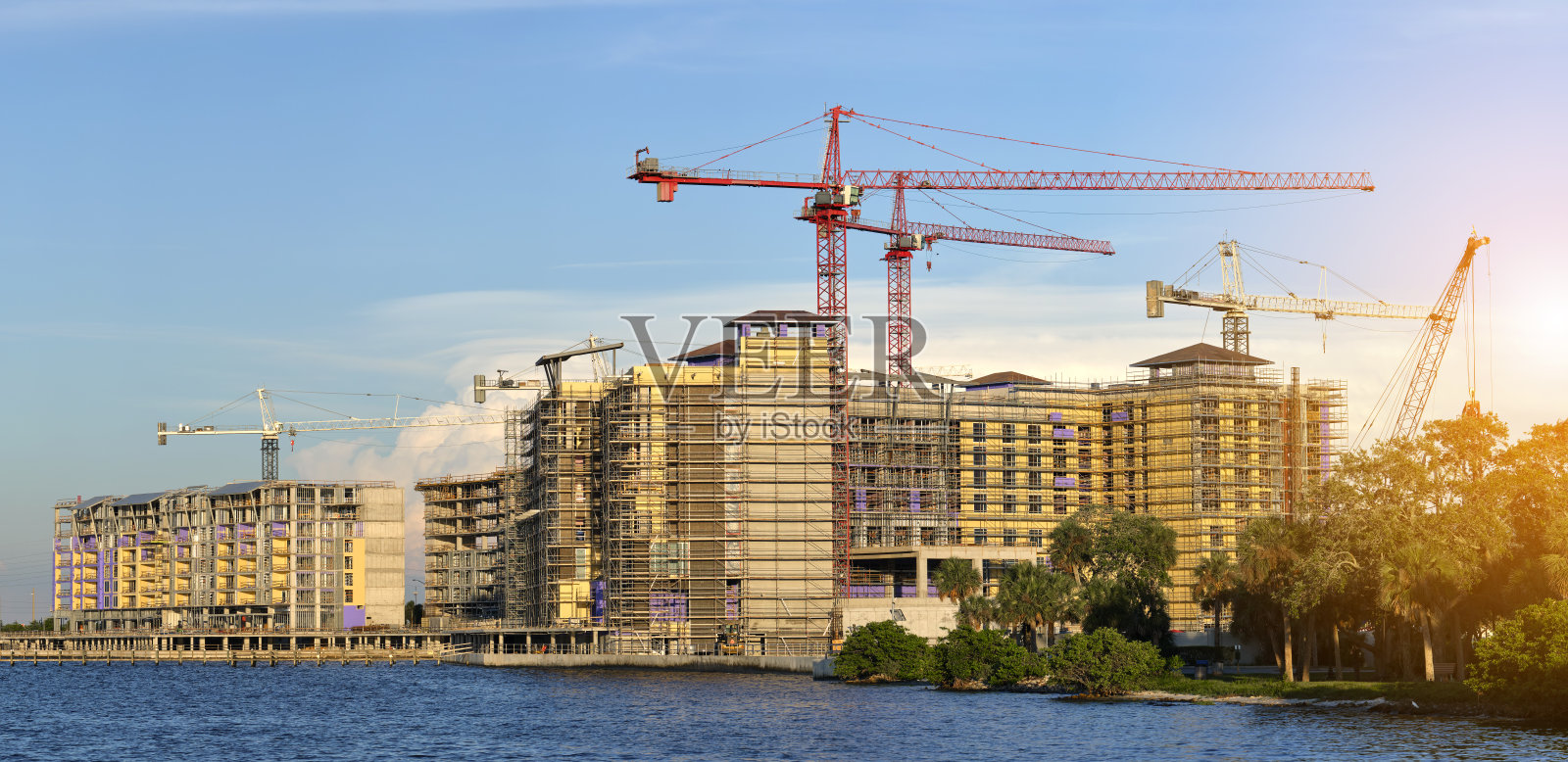 高层住宅公寓楼施工现场塔式起重机。房地产开发照片摄影图片