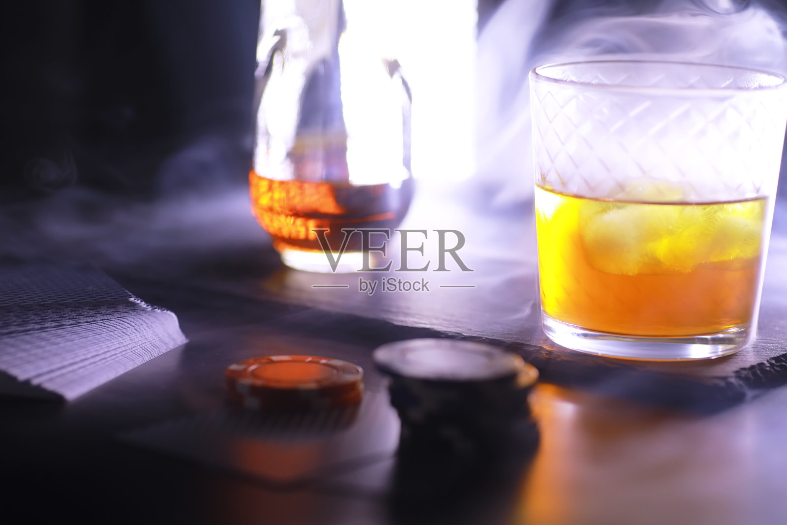 【赌博】赌钱的纸牌游戏德州扑克。手里有牌，玩筹码，一副牌，酒杯里有酒。照片摄影图片