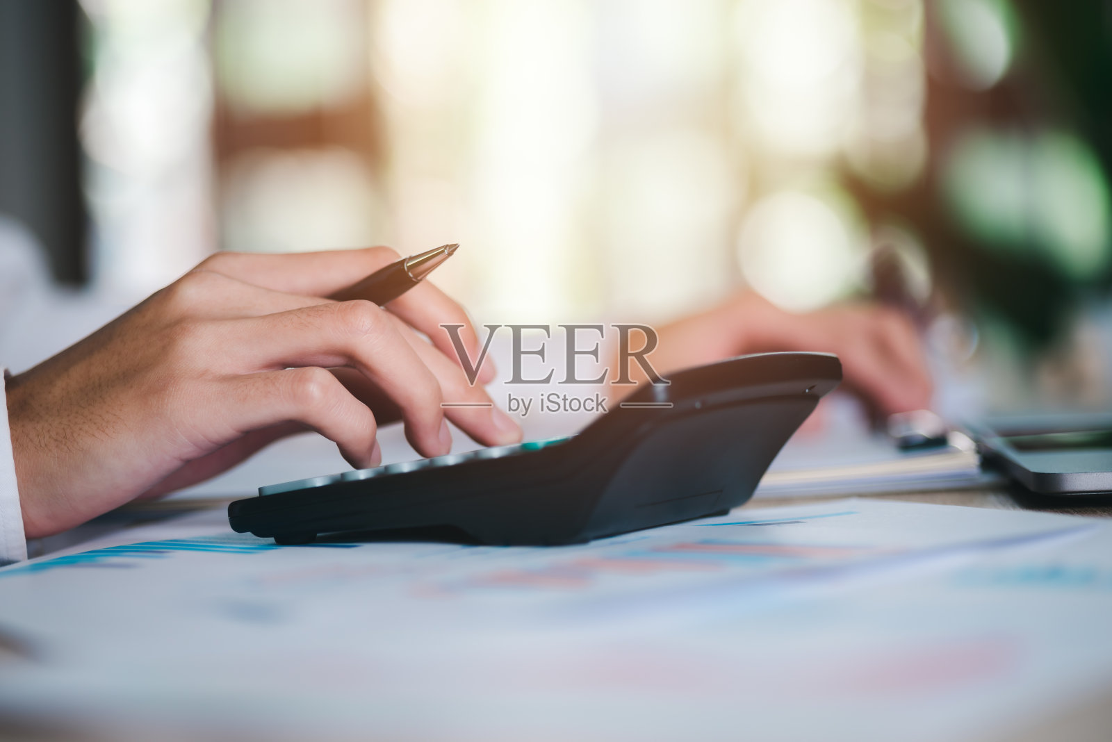 商务人士用计算器计算单据，审查损益表概念的公司业绩，有效筹划个人和公司的纳税抵扣税率照片摄影图片