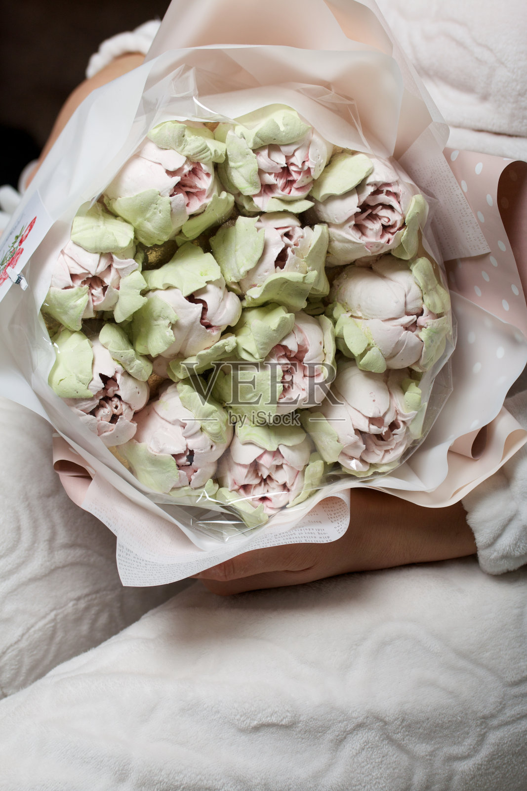 棉花糖的花束。西风郁金香。天然自制棉花糖。用纸包成花束。在一个女人的手里。特写镜头。照片摄影图片