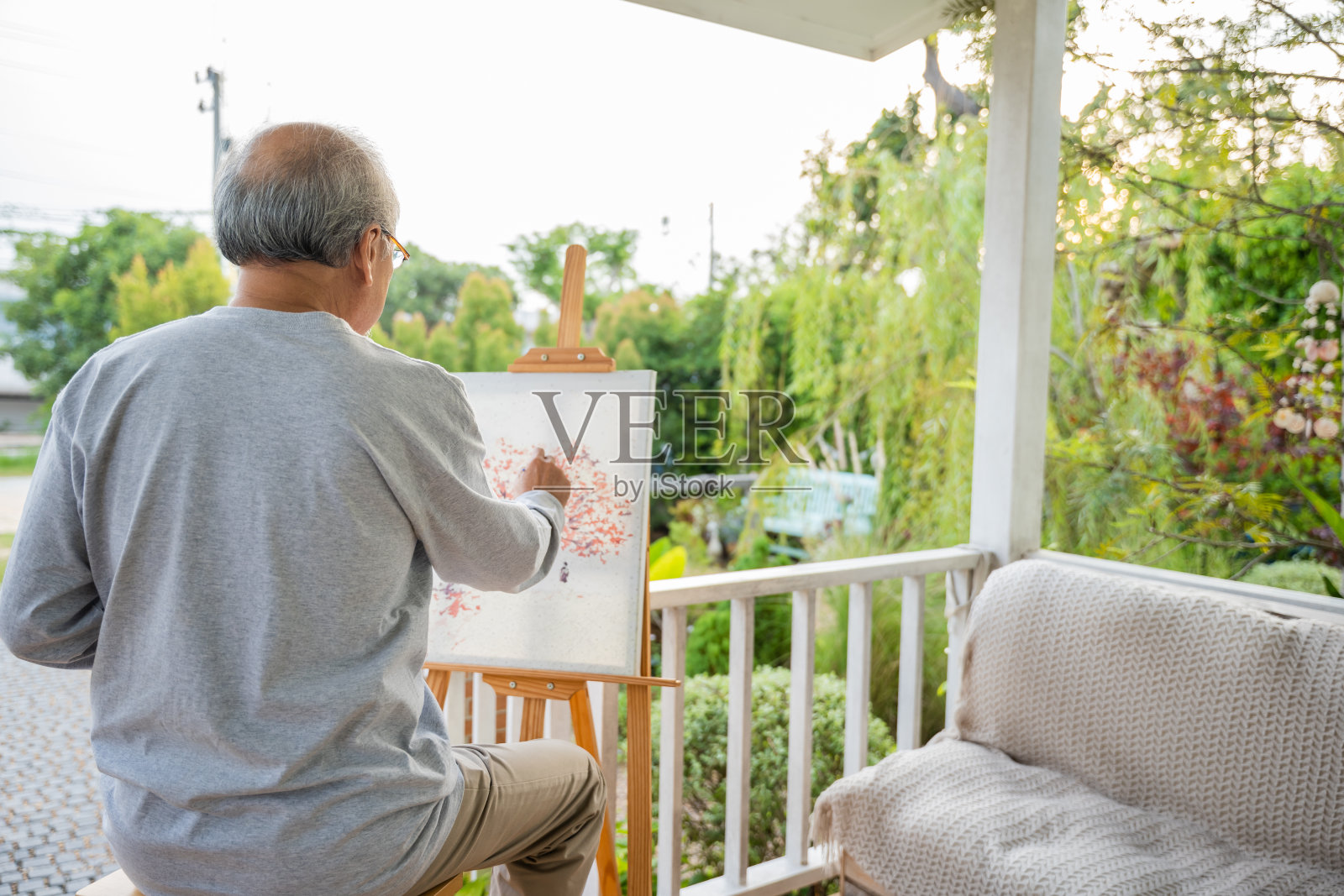 生活方式老人微笑着在家门口的画架上画画照片摄影图片