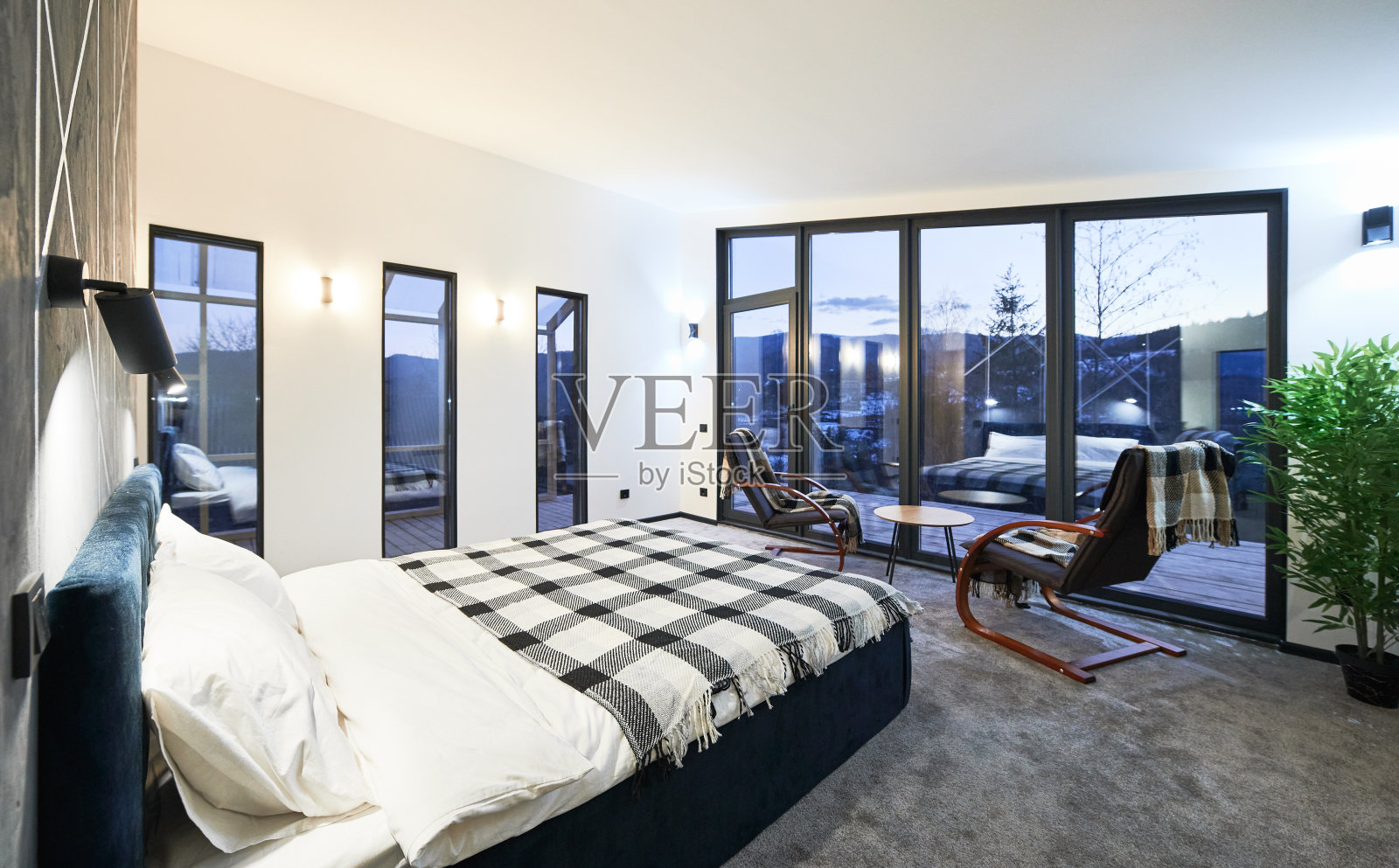 舒适的现代家具小屋，在黄昏时大窗户反射。照片摄影图片