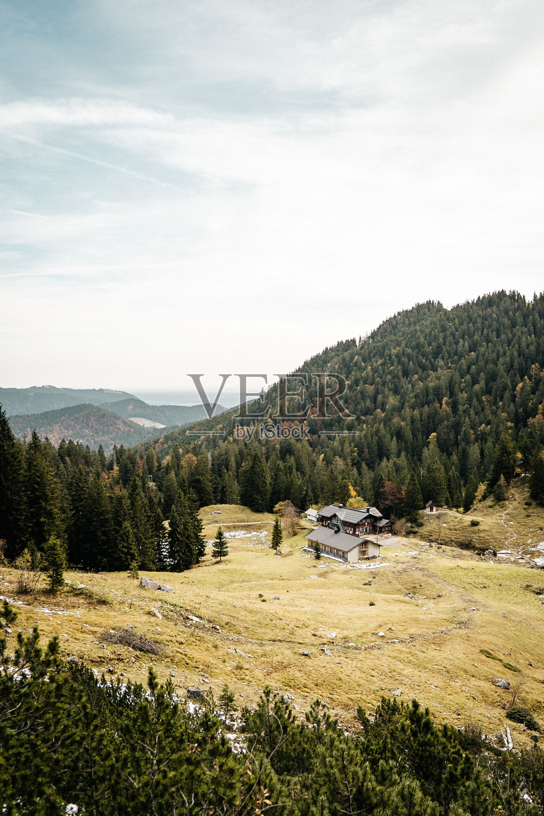 垂直拍摄岩石山上被森林包围的建筑物照片摄影图片