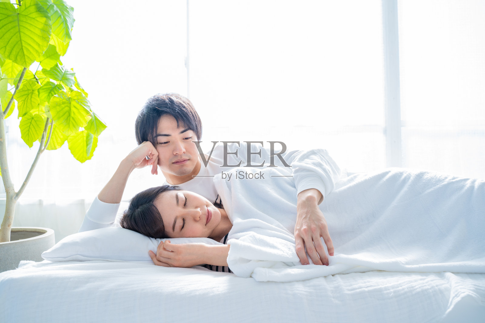 丈夫叫醒了睡在卧室床上的妻子。照片摄影图片