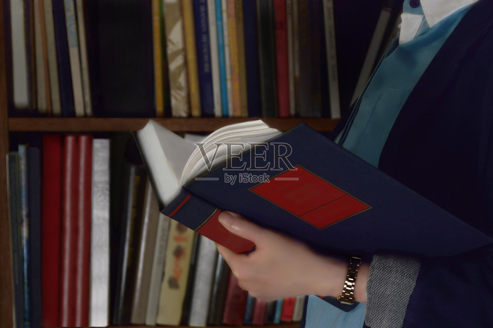 在书架前看书的女人照片摄影图片