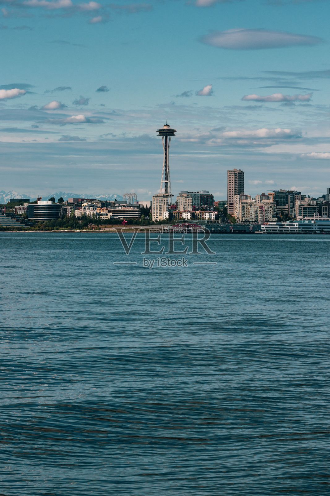 从阿尔基海滩和宁静的大海上垂直拍摄美丽的西雅图太空针塔照片摄影图片