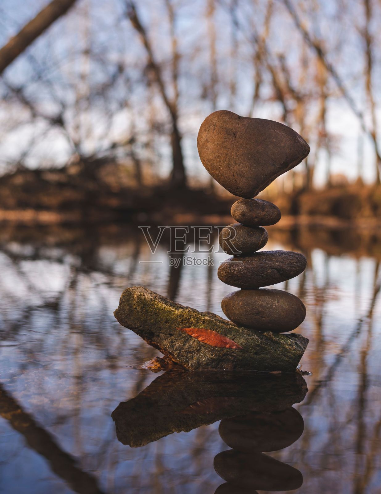 垂直拍摄的森林湖中的岩石相互平衡照片摄影图片