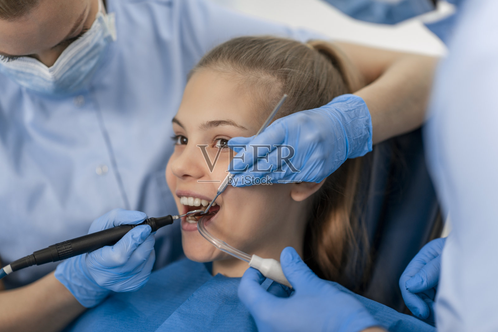 女牙医检查病人的牙齿照片摄影图片