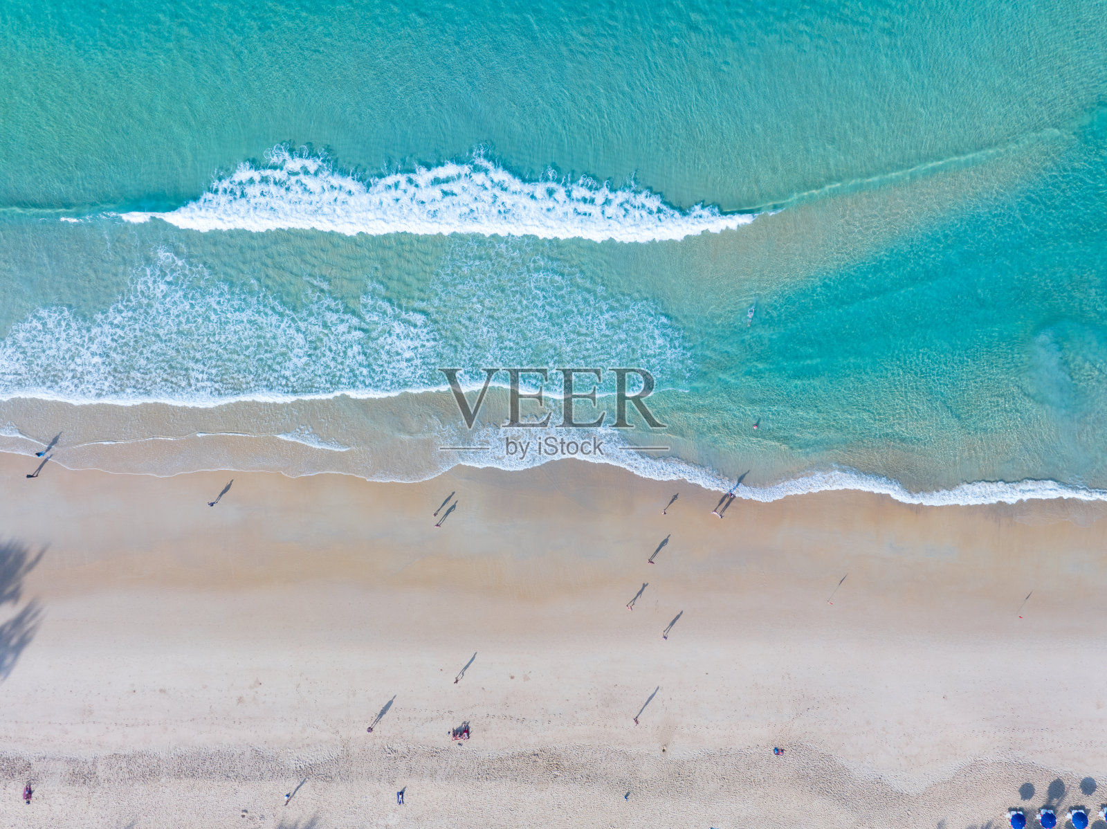 美丽的海浪水面，沙滩沙滩海岸和波浪白色泡沫夏日阳光明媚的日子背景。令人惊叹的海滩自上而下俯瞰海滨自然背景照片摄影图片
