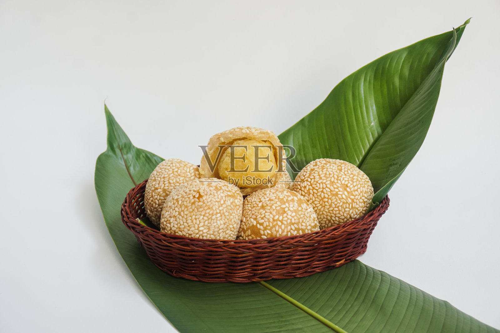 芝麻球(煎对)放在竹篮和香蕉叶上。印尼流行小吃，由糯米粉加上少量米粉和糖和绿豆沙制成。有选择性的重点照片摄影图片