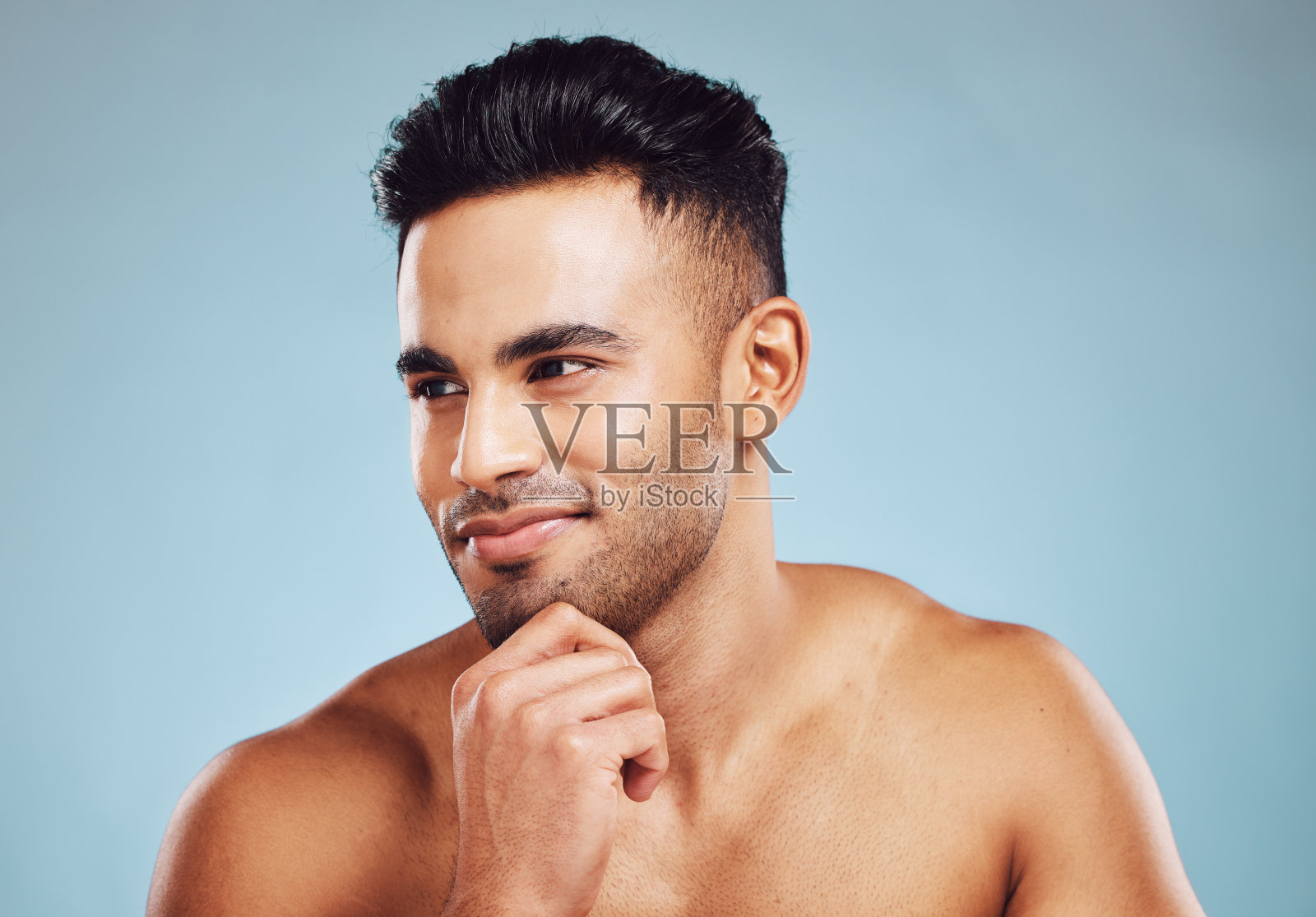 男性美容，护肤和健康的印度模特思考皮肤病学，健康和健康的蓝色工作室背景。男士面带微笑，面部排毒及自我护理后肌肤健康照片摄影图片