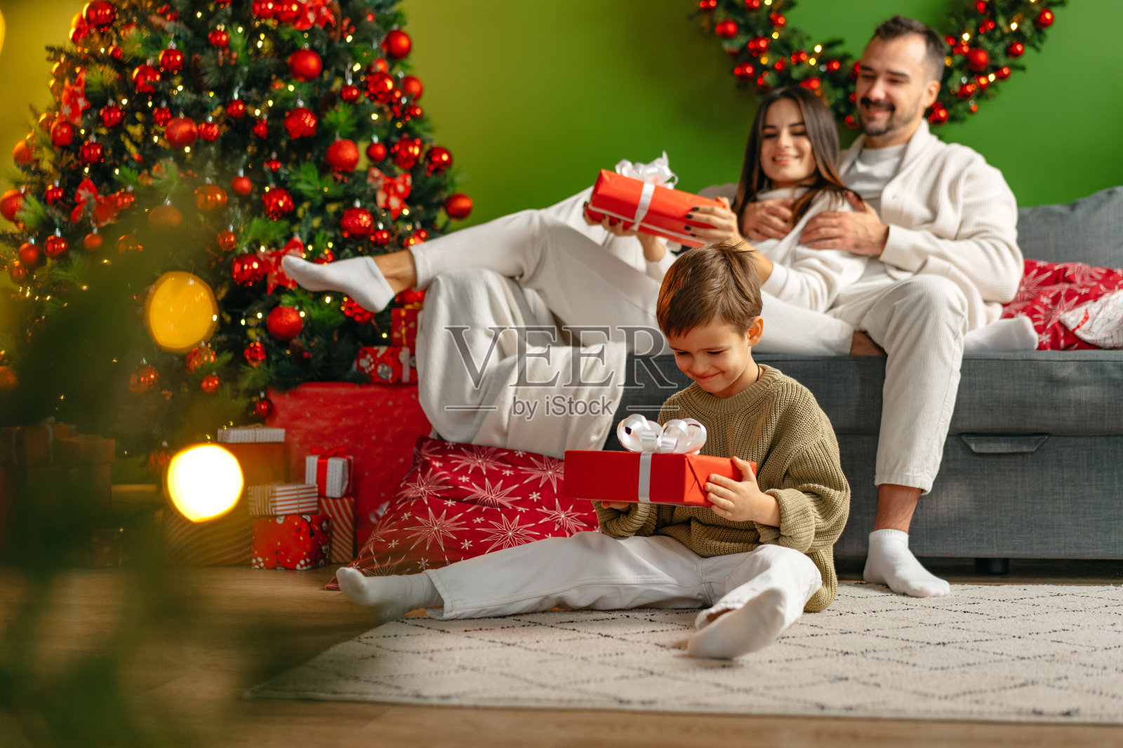 圣诞节快乐的年轻家庭坐在沙发上，在家里放松照片摄影图片